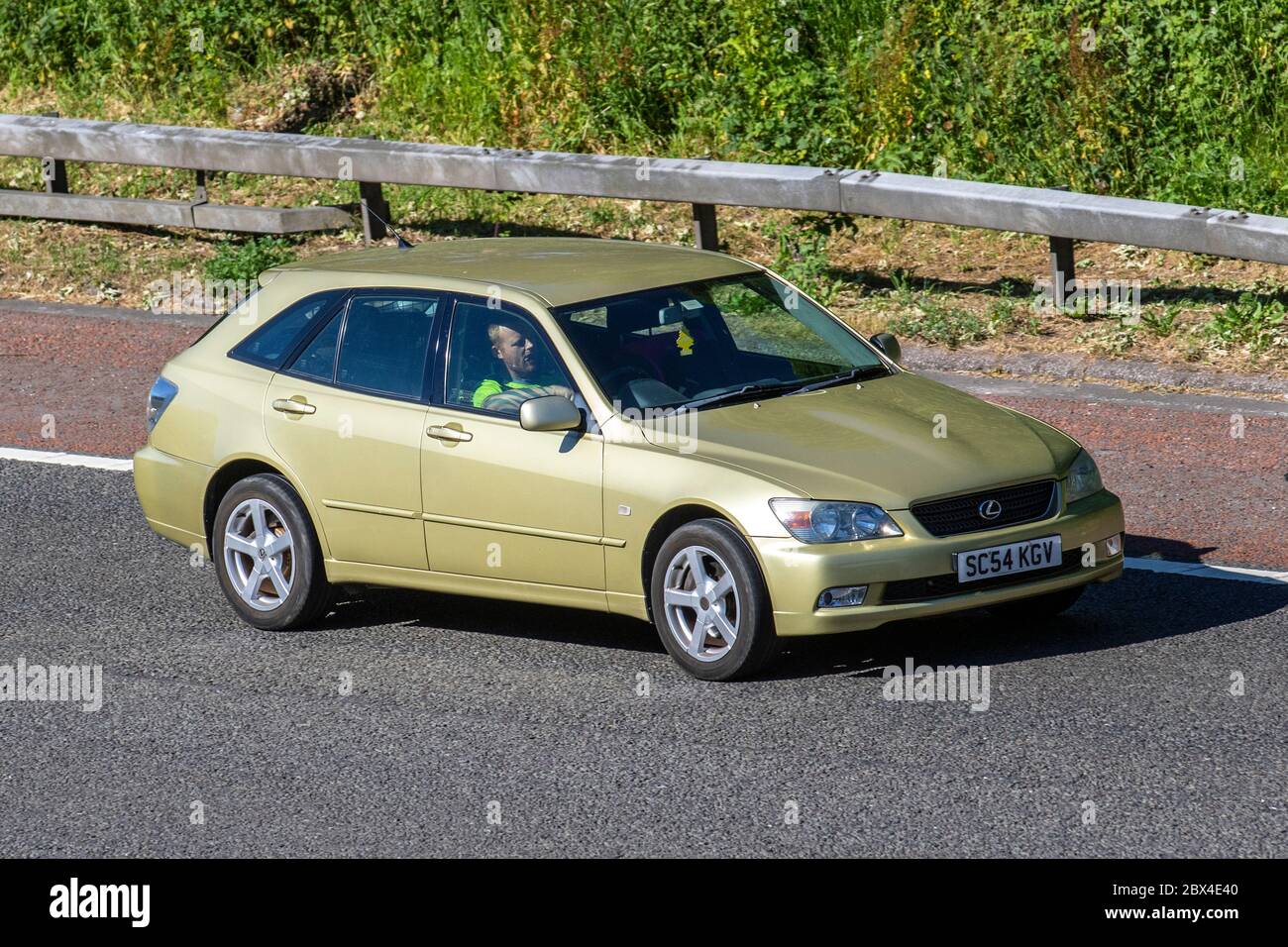 2004 beige Lexus IS 200 Sportcross; Vehicular traffic moving vehicles, cars driving vehicle on UK roads, motors, motoring on the M61 motorway Stock Photo