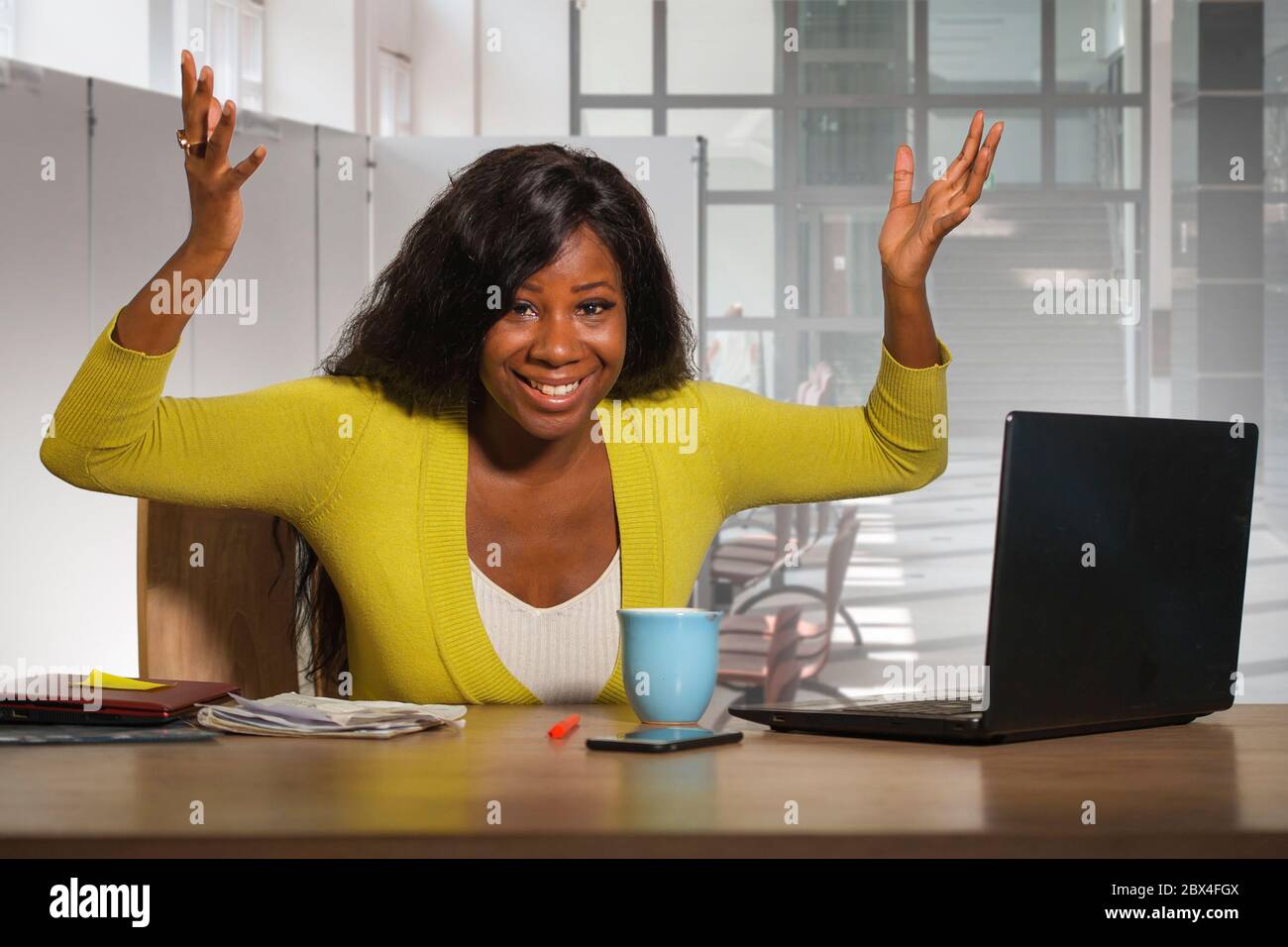 young happy and attractive black afro American business woman smiling confident working at office computer desk in successful businesswoman celebratin Stock Photo