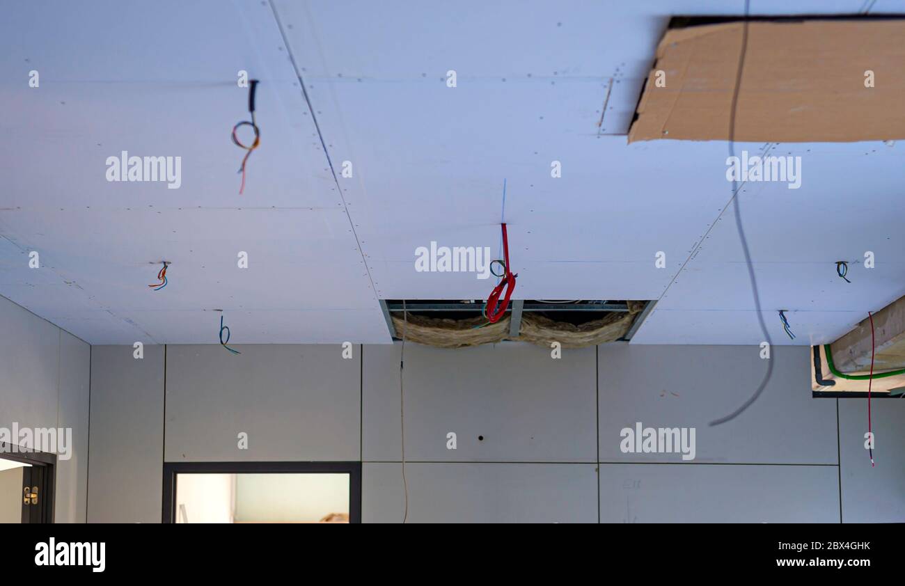 Suspended ceiling with drywall and fixing the drywall to the ceiling metal frame. Stock Photo
