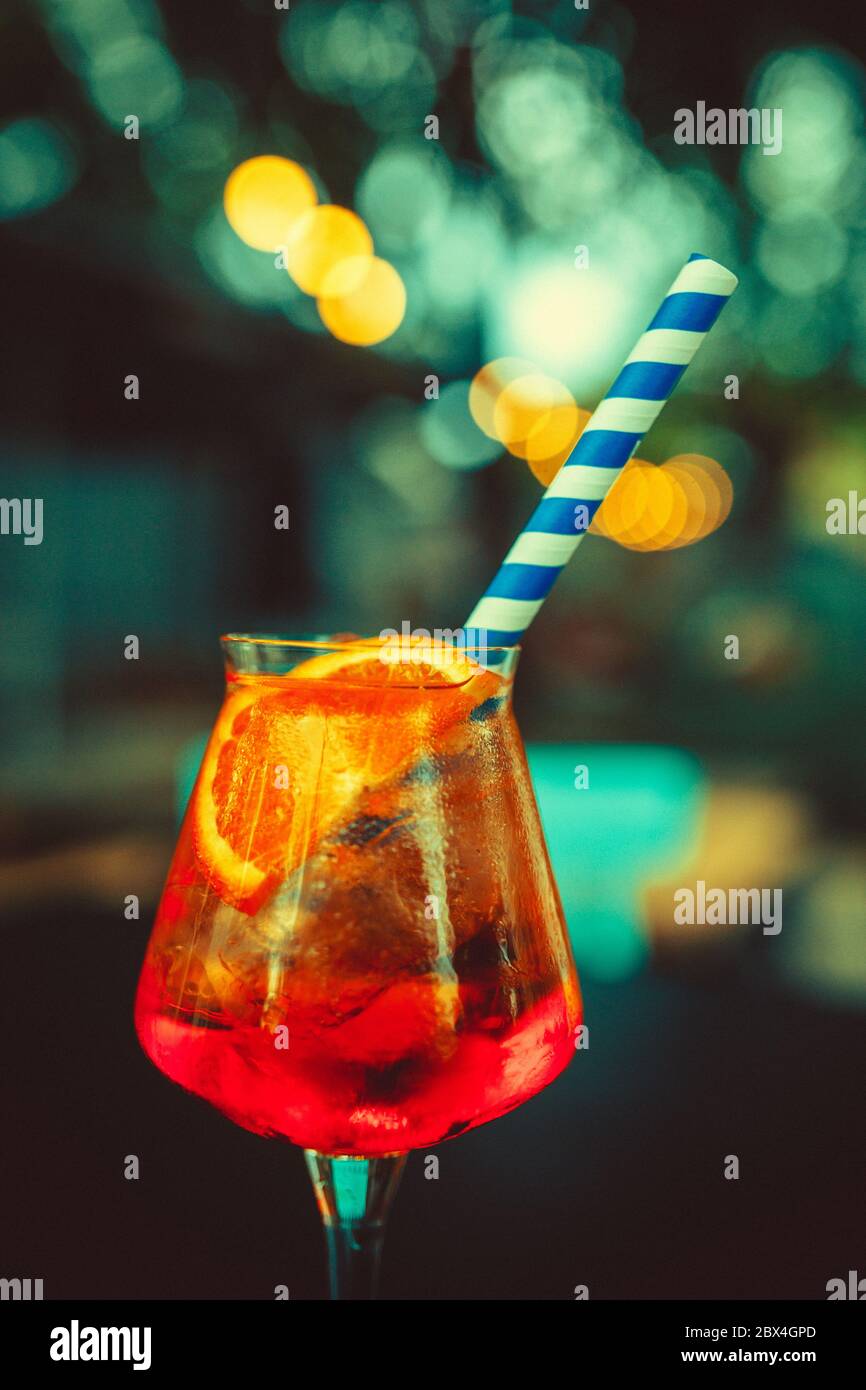 https://c8.alamy.com/comp/2BX4GPD/glass-of-aperol-spritz-and-blue-straw-italian-cocktail-fine-film-grain-texture-2BX4GPD.jpg