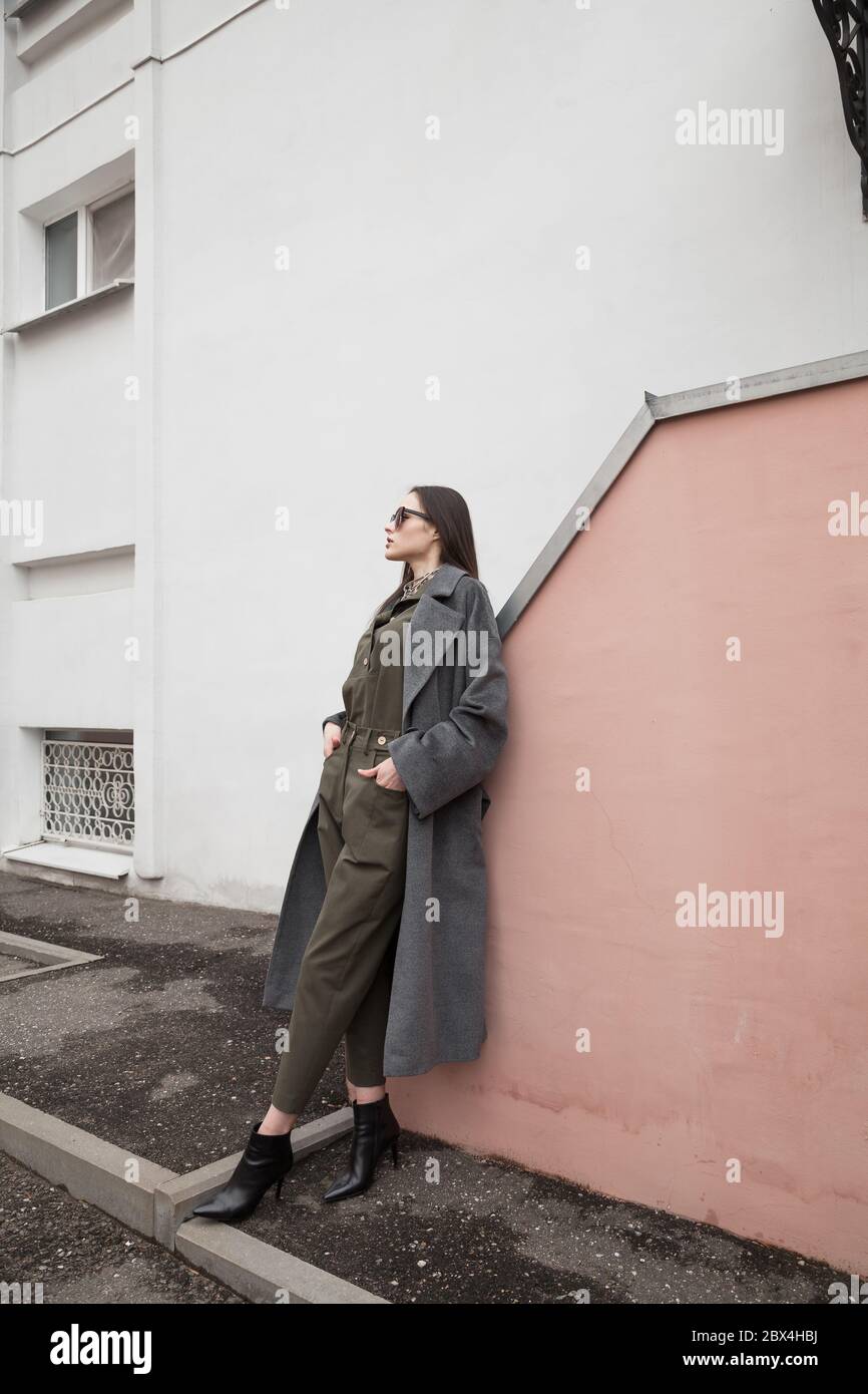 Copy, empty space for text Brunette hair woman skinny body shape tan skin care wear fashion pants suit and long warm coat runway model outdoor catalog Stock Photo