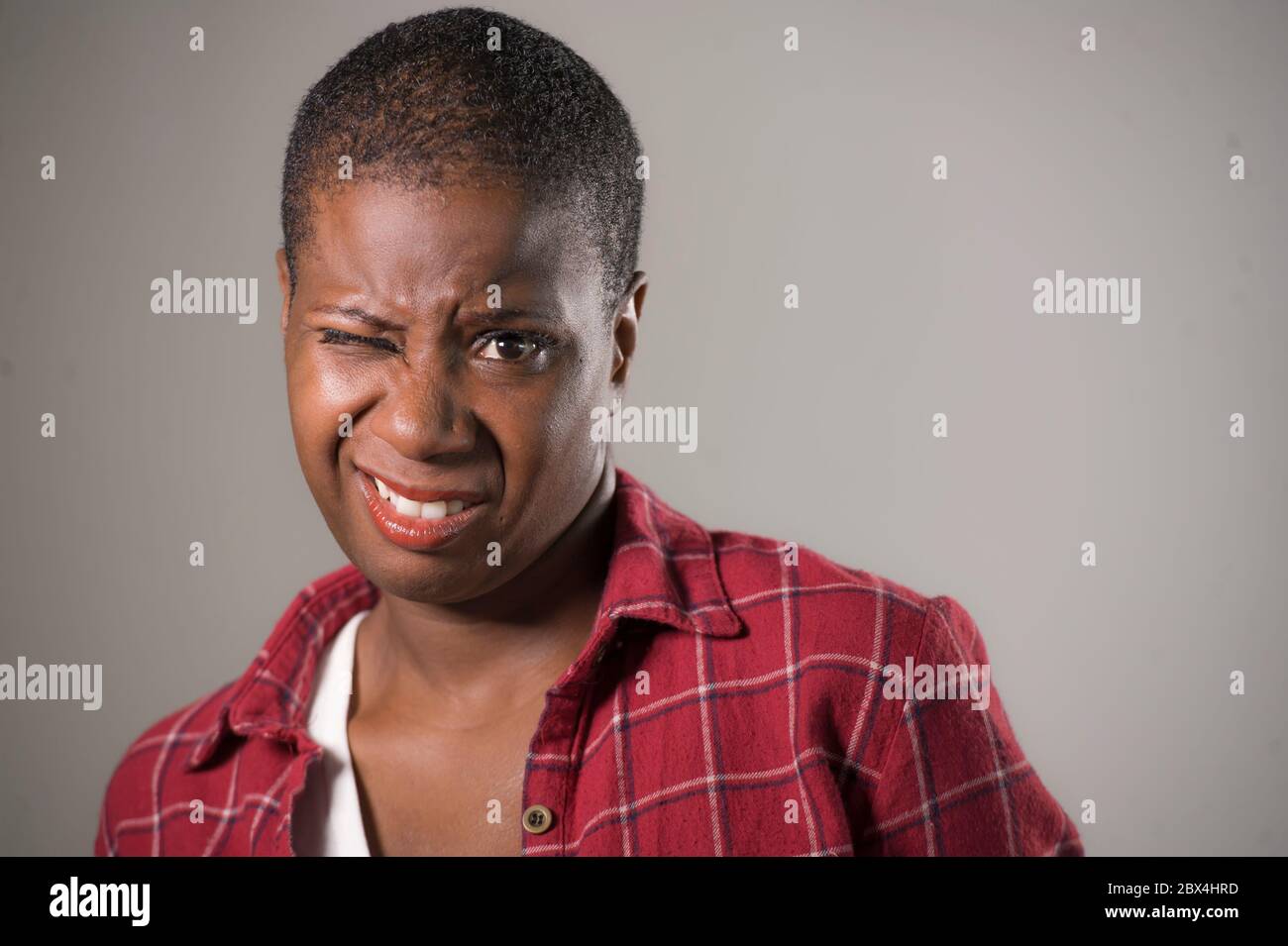 lifestyle portrait if young unhappy and pretty african American woman in contempt and disgust face expression as if disliking or finding disgusting is Stock Photo
