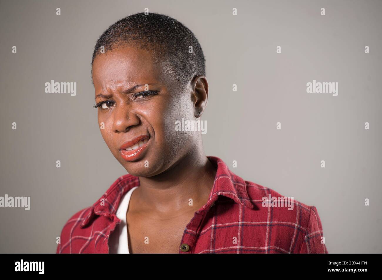 lifestyle portrait if young unhappy and pretty afro American woman in contempt and disgust face expression as if disliking or finding disgusting isola Stock Photo