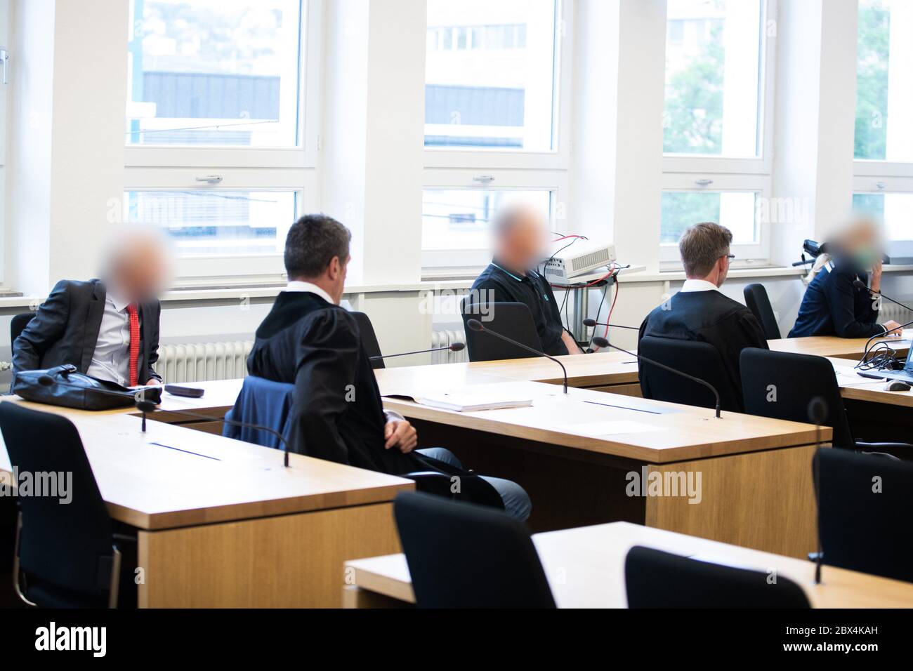 05 June 2020, Baden-Wuerttemberg, Stuttgart: The three defendants (back row) sit next to their lawyers in the courtroom at the beginning of the trial. With allegedly lucrative gold trading deals, a woman and two men are said to have robbed investors of two million euros. The trial is scheduled for the end of September. Photo: Tom Weller/dpa - ATTENTION: Person(s) has (have) been pixelated for legal reasons Stock Photo