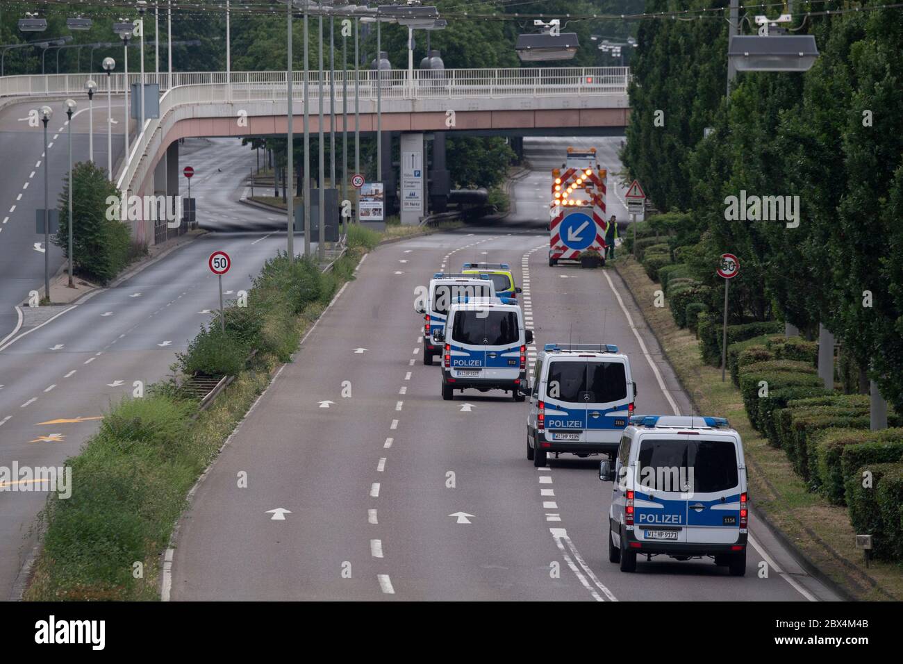 05 June 2020, Hessen, Frankfurt/Main: In the run-up to the defusing of a world war bomb, police vehicles seal off a central access road. The explosive device from the Second World War had been found during construction work on the exhibition grounds and is to be defused in the course of the morning. Several thousand people have to leave their homes, and the area is cordoned off over a large area. Photo: Boris Roessler/dpa Stock Photo