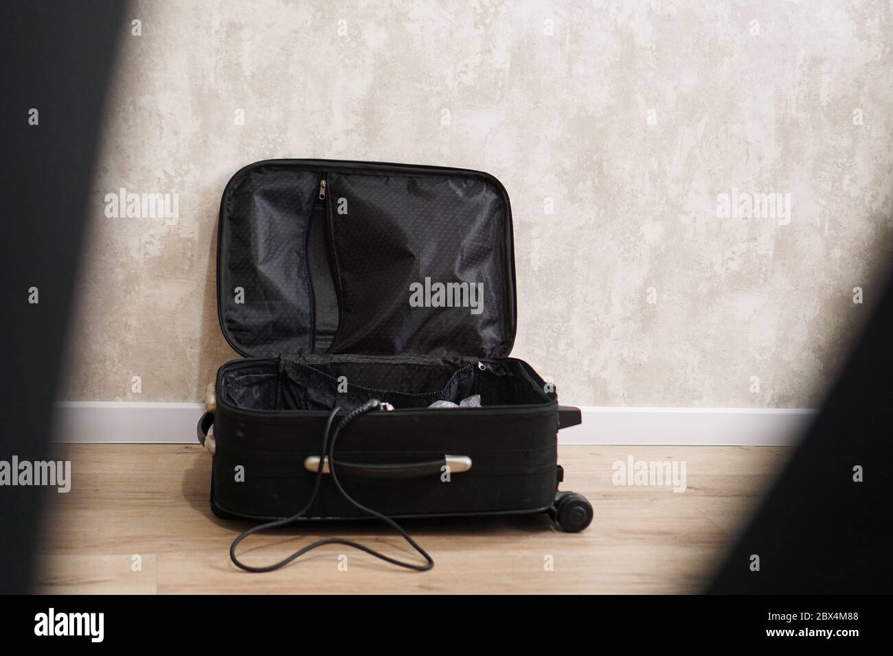 Opened empty, black suitcase for different things on gray background. Travel preparation concept Stock Photo