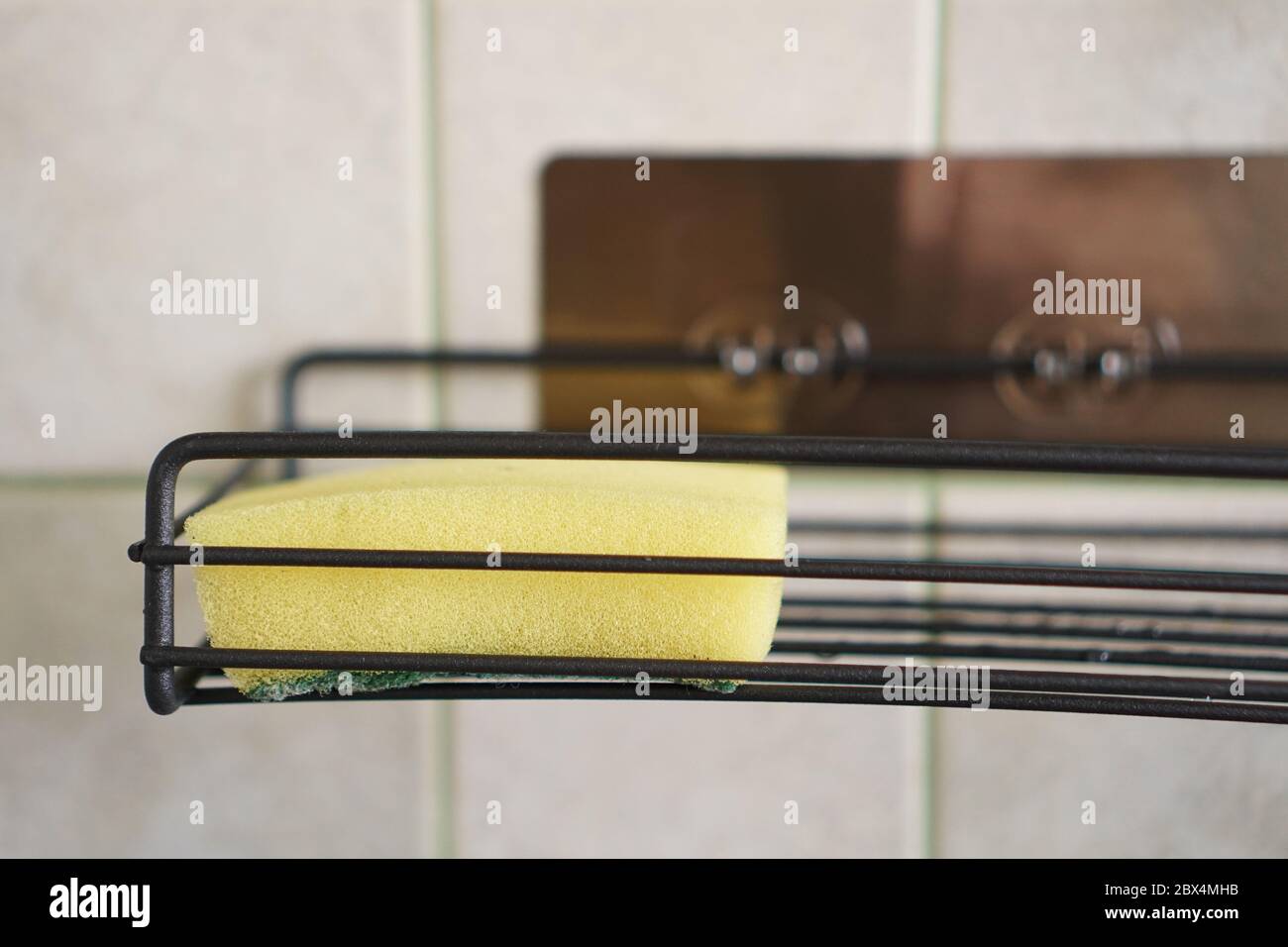 Sponge for washing dishes on metal shelf in kitchen. Concept of cleaning. Close-up interior. No people. Stock Photo