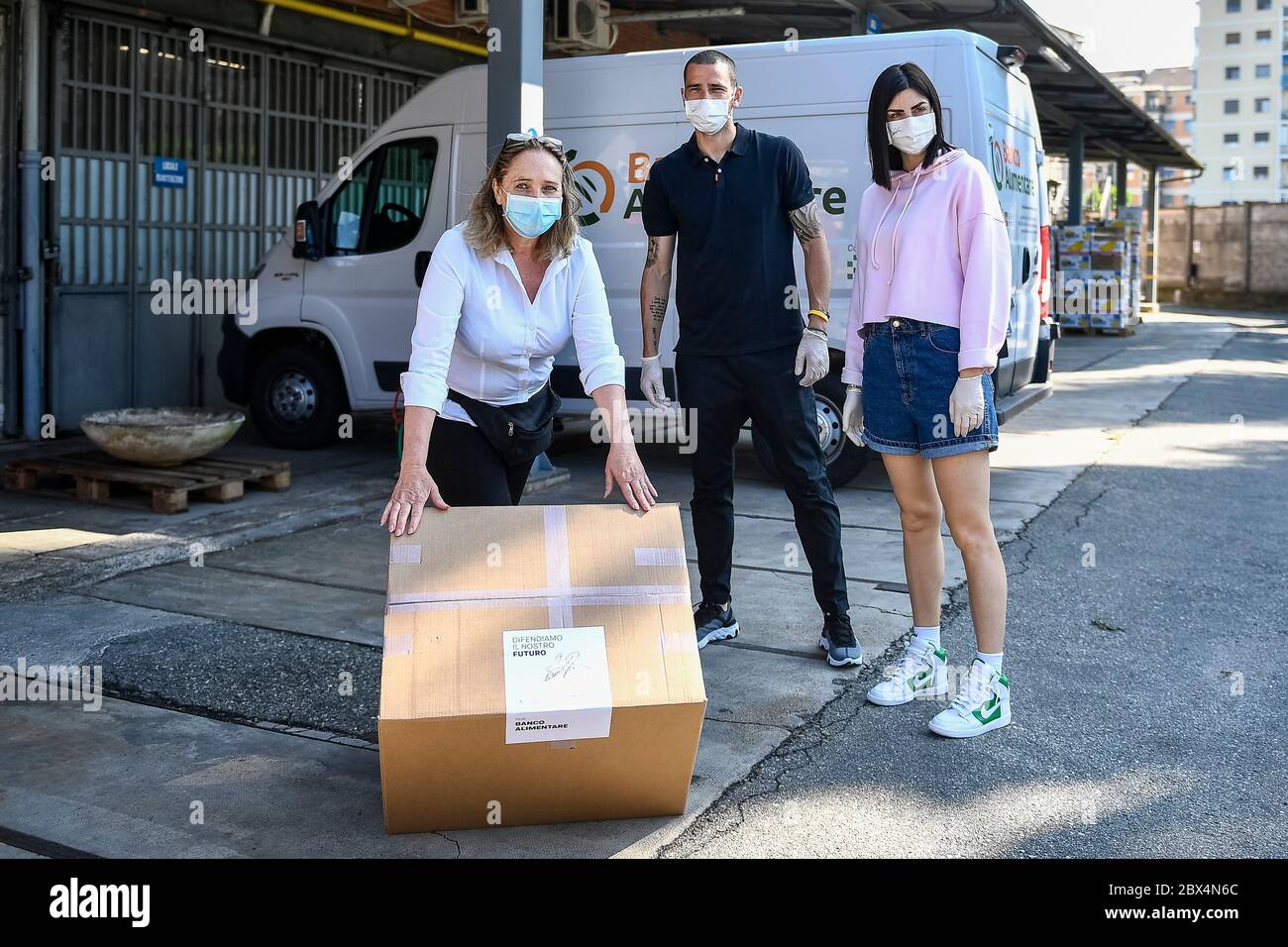 Moncalieri, Italy. 05th June, 2020. MONCALIERI, ITALY - June 05, 2020: Juventus player Leonardo Bonucci (C), his wife Martina Maccari (R) and a member of Associazione Banco Alimentare Del Piemonte (Piedmont Food Bank Association) pose for a photo after the delivery of a box full of masks. Leonardo Bonucci and his wife Martina Maccari delivered 19.000 masks made by the company Sire Tessil to 19 social-beneficial associations and companies. (Photo by Nicolò Campo/Sipa USA) Credit: Sipa USA/Alamy Live News Stock Photo