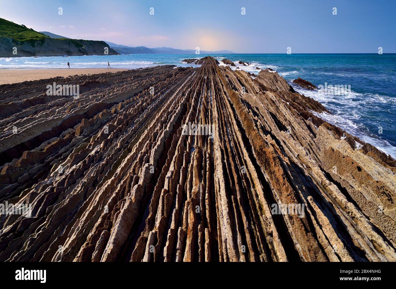 Close up view of rock lines heading to the ocean at low tide beach Stock Photo
