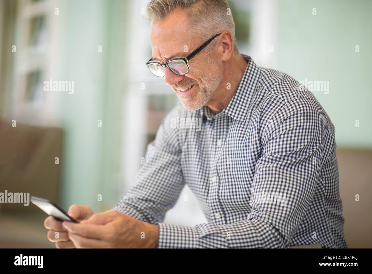 Mature handome man sitting outside reading his emails. Stock Photo