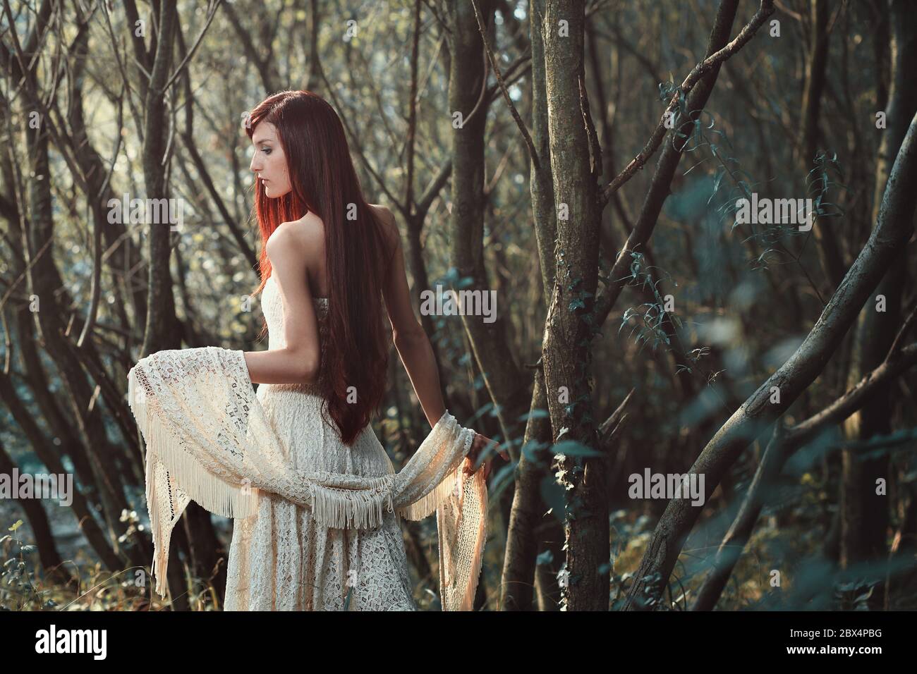 Beautiful red hair woman posing in the woods . Ethereal and romantic Stock Photo
