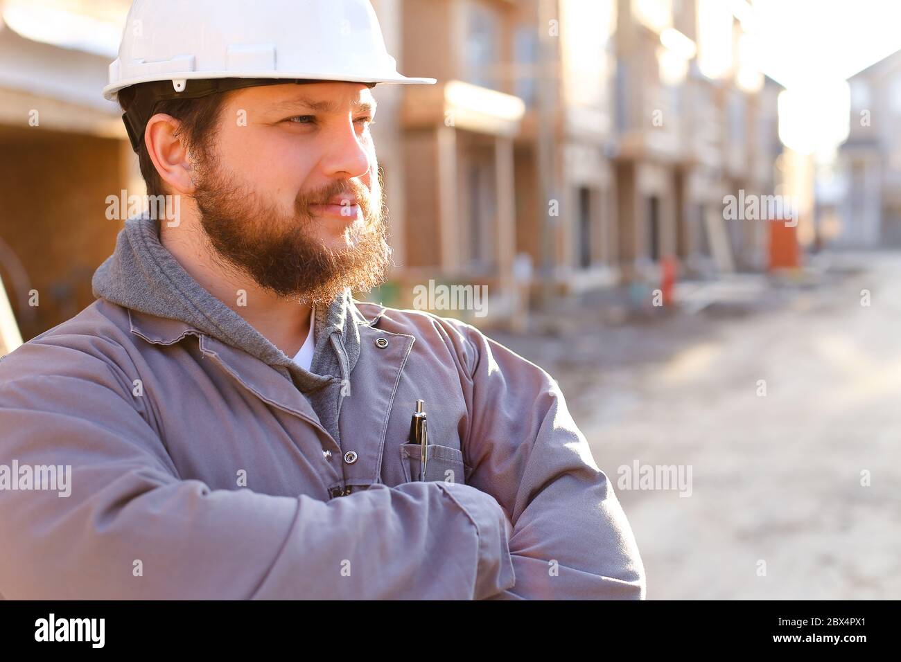 Portrait of construction manager and builder wearing hardhat. Stock Photo