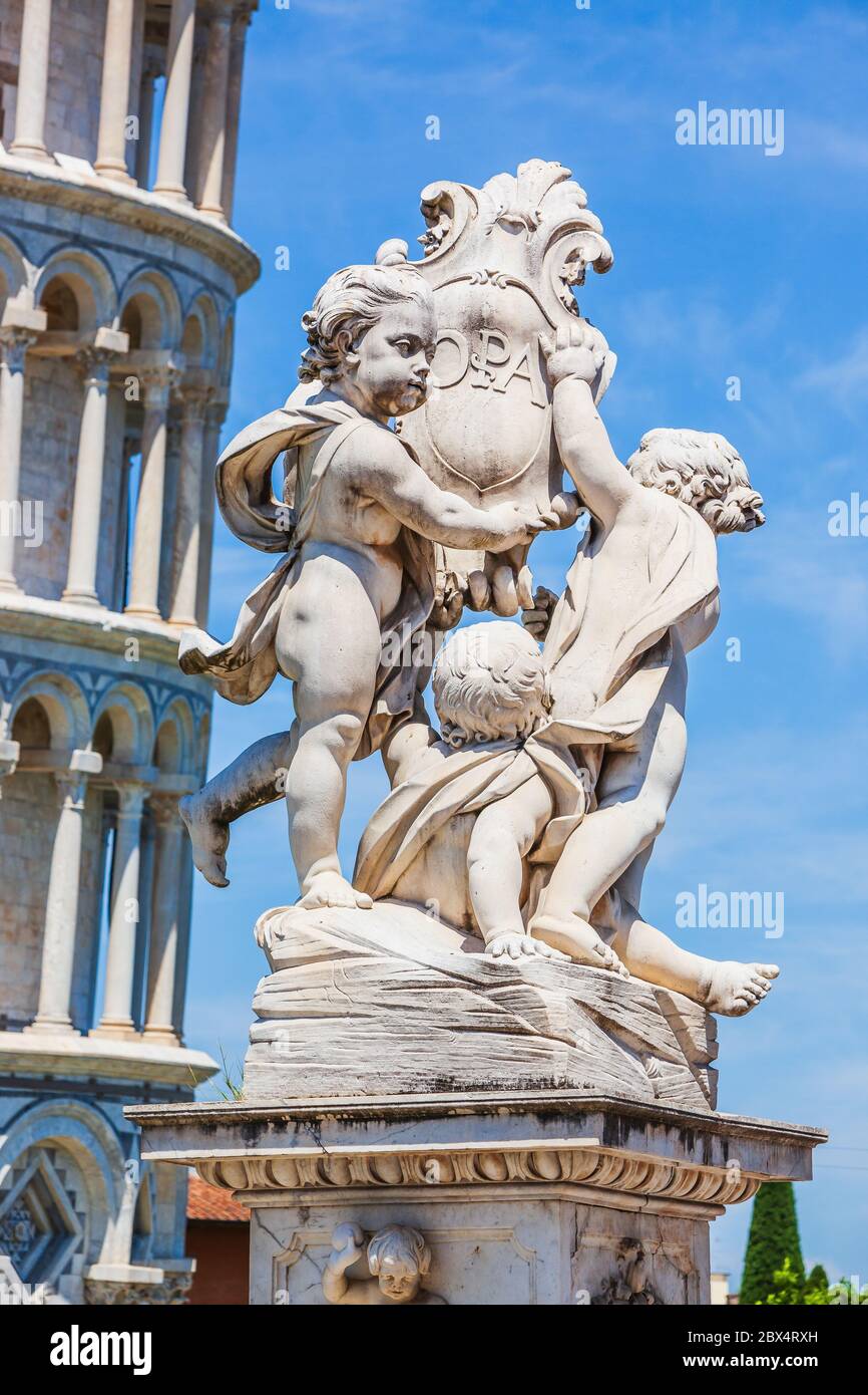 Cupid statue and the Leaning Tower of Pisa in Piazza dei Miracoli (Square of Miracles),  Italy. Stock Photo