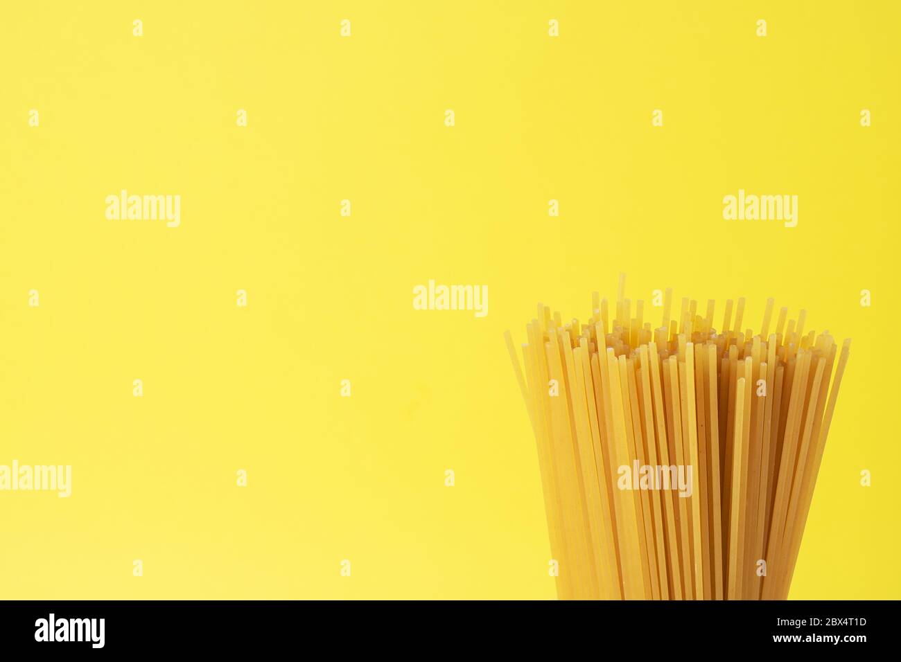 Dry pasta spaghetti on a yellow background. Copy space Stock Photo