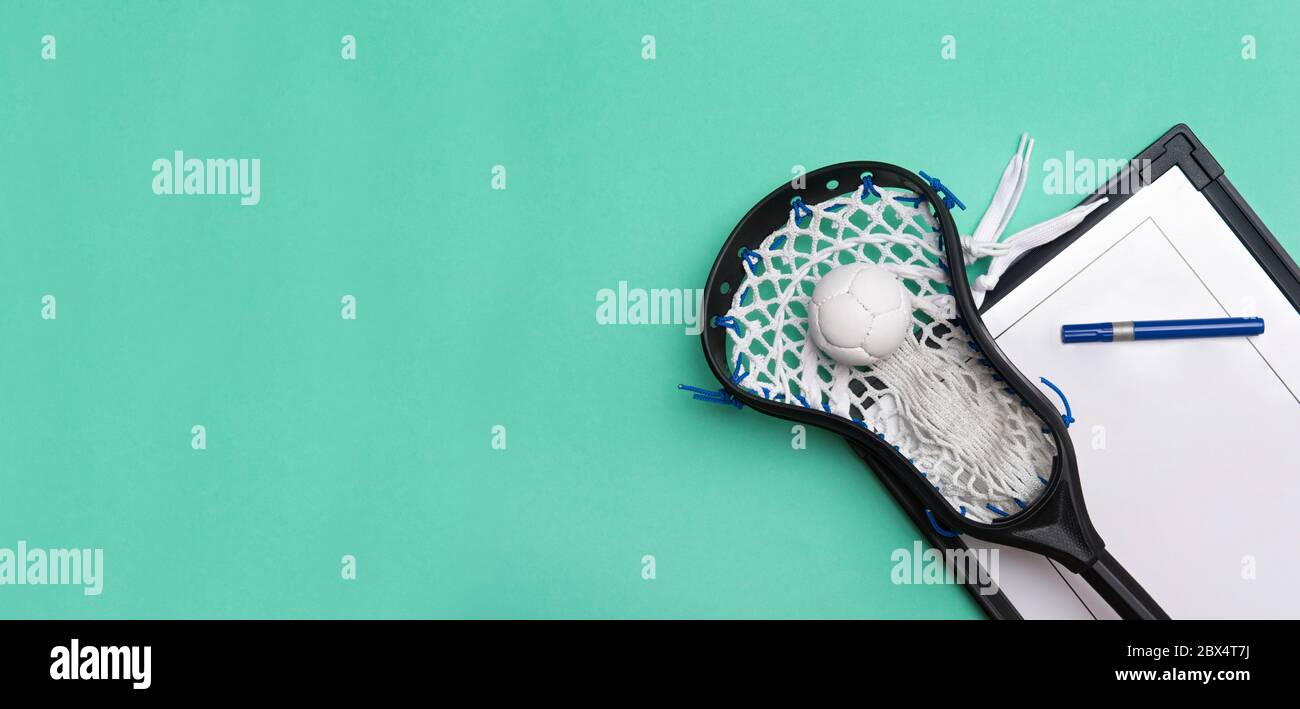 Lacrosse stick, ball and tactical board with marker on green background. Sport coach concept Stock Photo