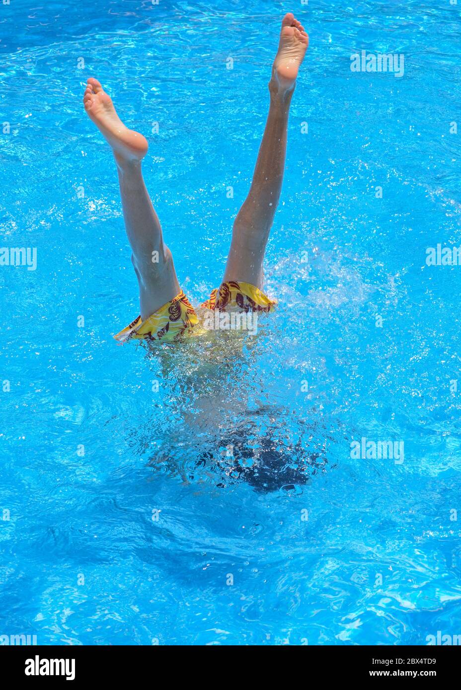 Young boy doing a handstand in a swimming pool in the Larnaca area of
