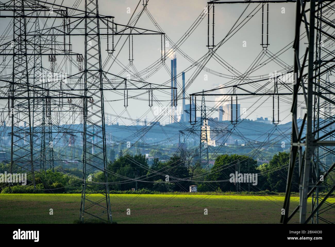 High-voltage lines, electricity pylons, in the Wattenscheid district, run to Gelsenkirchen, at the back coal-fired power station Gelsenkirchen-Scholve Stock Photo