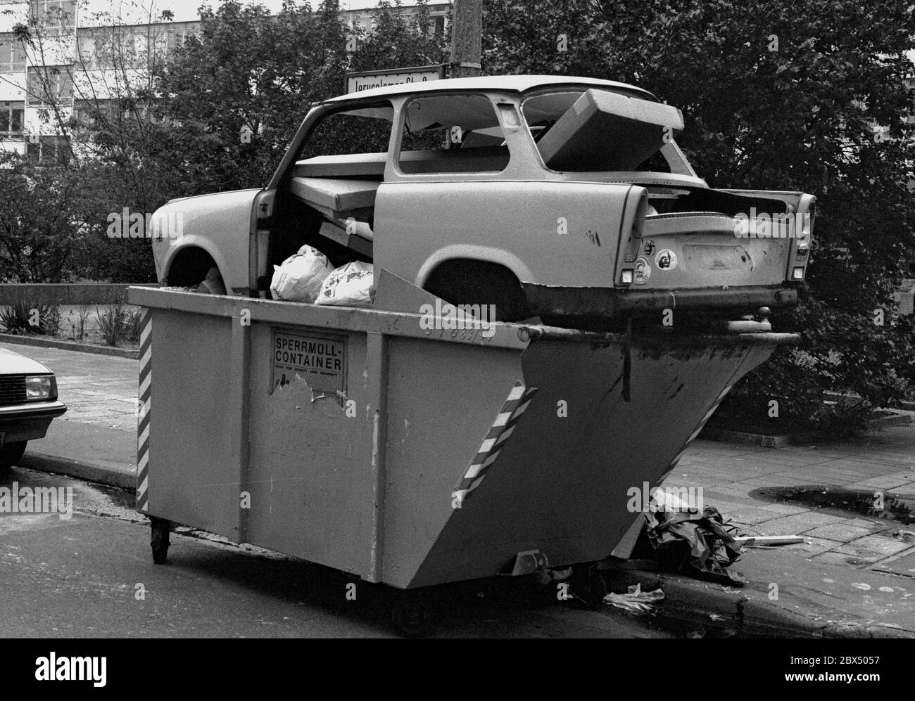 Berlin-Mitte / GDR / 1990 A Trabi, symbol of GDR prosperity, is disposed of, near Leipziger Strasse, a symbol for the end of the GDR // Muell / Abfall / Einigung / Wende / Wirtschaft / *** Local Caption *** East Germany / CommunismThe car Trabi-Trabant was the standard car in communist Germany, a sign for moderate wealth. After the unification those cars were only junk, like big parts of the whole economy. [automated translation] Stock Photo