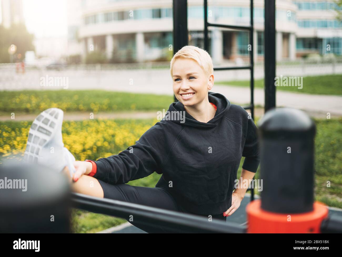 Attractive fit young woman in sport wear stretching on street workout area. Healthy lifestyle in city Stock Photo
