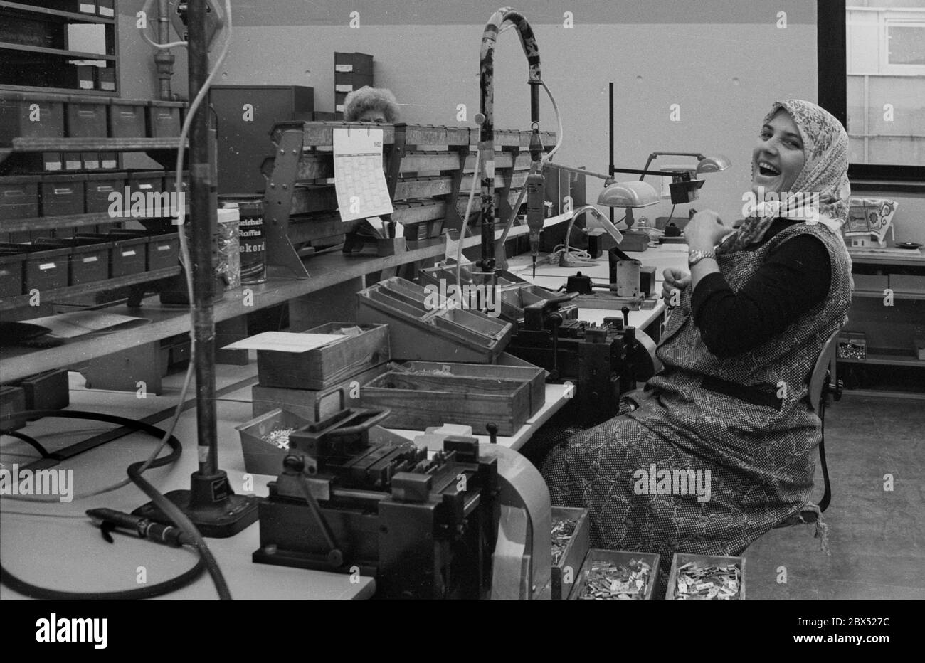 Berlin Districts / Turks / Foreigners 17.10.1980 Kreuzberg: Turkish woman at her workplace.  DeTeWe, Deutsche Telefon-Werke. The company produces switchboards for the post office. The women produce parts in prefabrication. In the next generation of technology these works are done by automatic machines // Women / Work / Industry / History / *** Local Caption *** Foreigners / Turks Turkish woman mounting telephone equipment [automated translation] Stock Photo