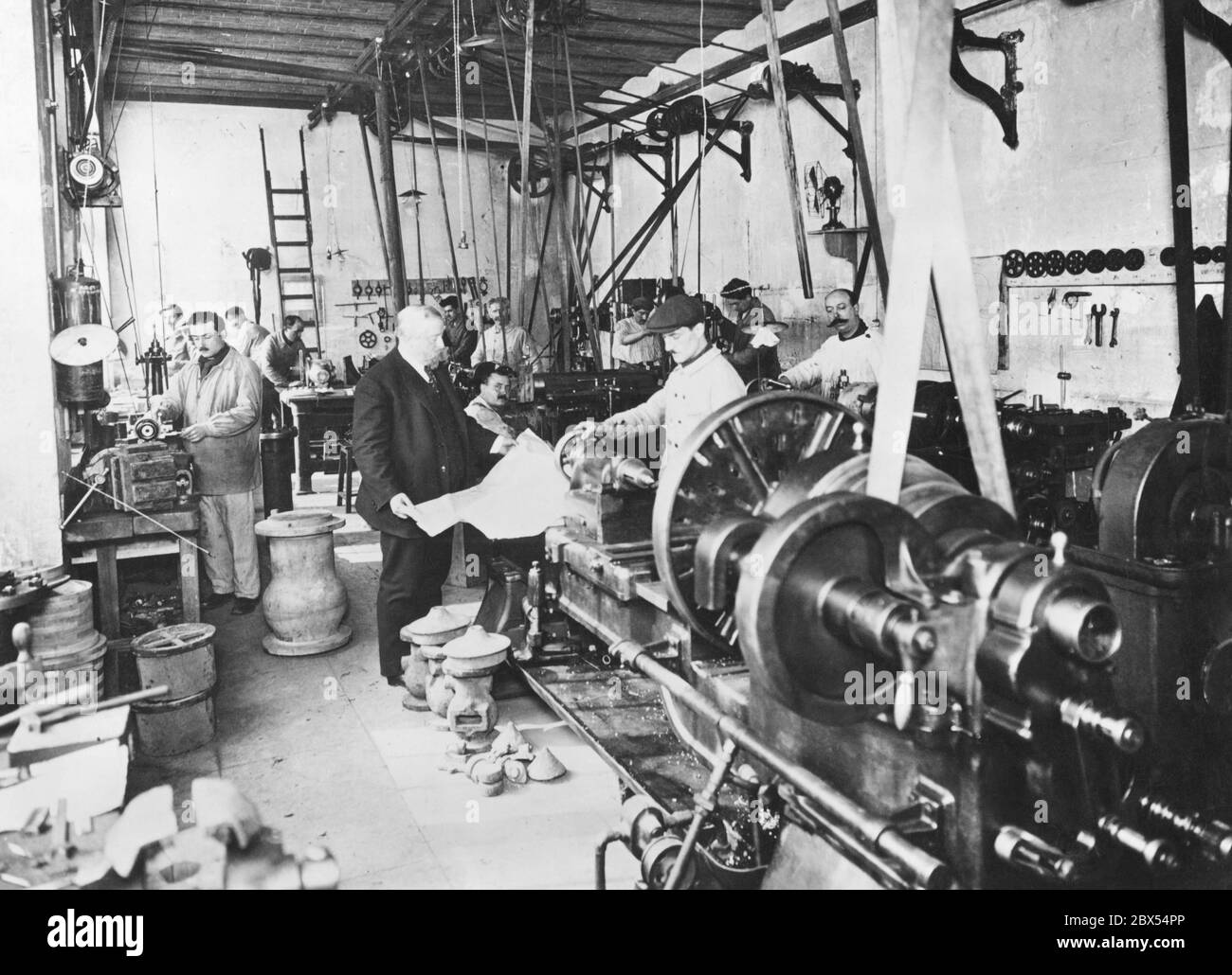 Factory manager and workers in a small steel production company. Stock Photo