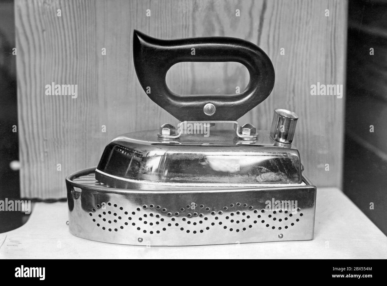 An electric flat iron with a base that automatically switches off the iron and thus saves electricity. Undated photo. Stock Photo