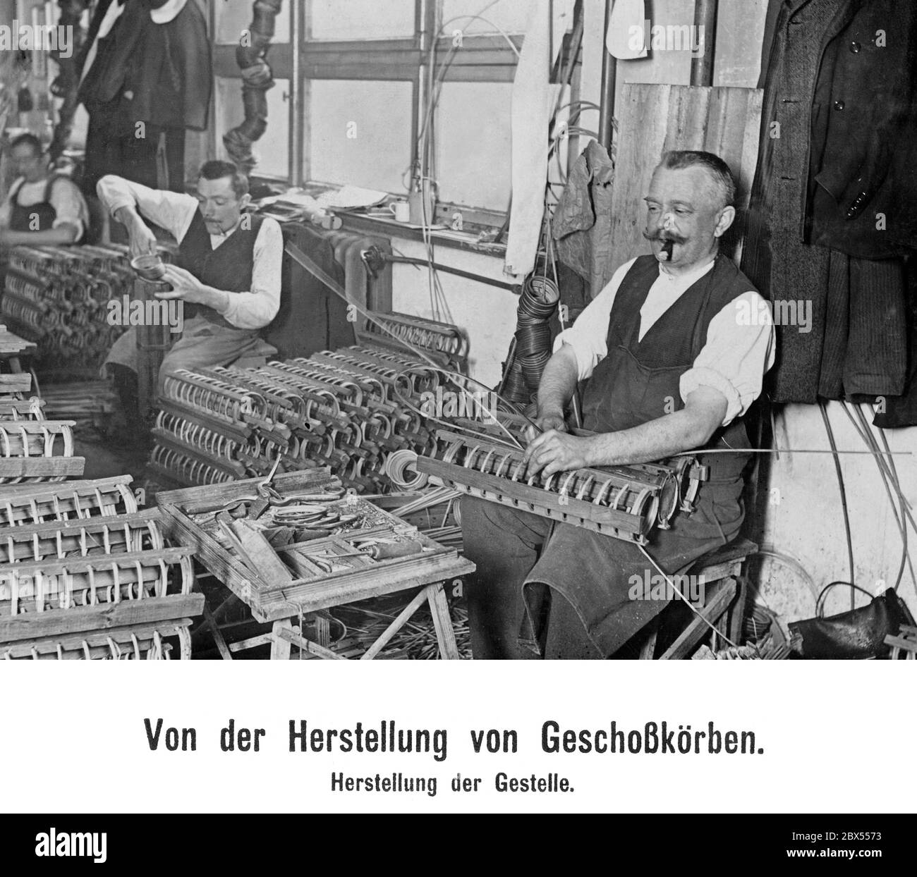 Workers making frames for the Geschosskoerbe ('baskets to be used for transport of ammunition'). Stock Photo