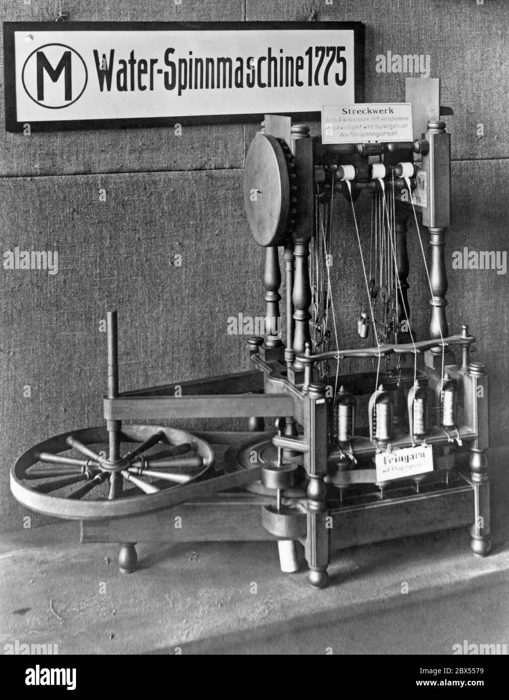 Exhibit in the Deutsches Museum in Munich. On display is one of the first functioning spinning machines: the water frame from England, constructed in 1775. It is accompanied by explanations on the functioning of the machine that spun the twine into fine yarn. The picture was probably taken in the 1930s. Stock Photo