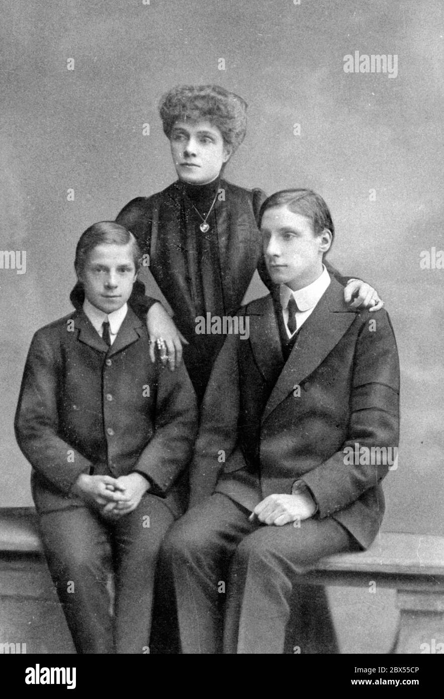 Two sons from upper class families with their mother. The boys wear the typical youth clothing of the upper classes, a suit with a stiff collar and tie. Stock Photo
