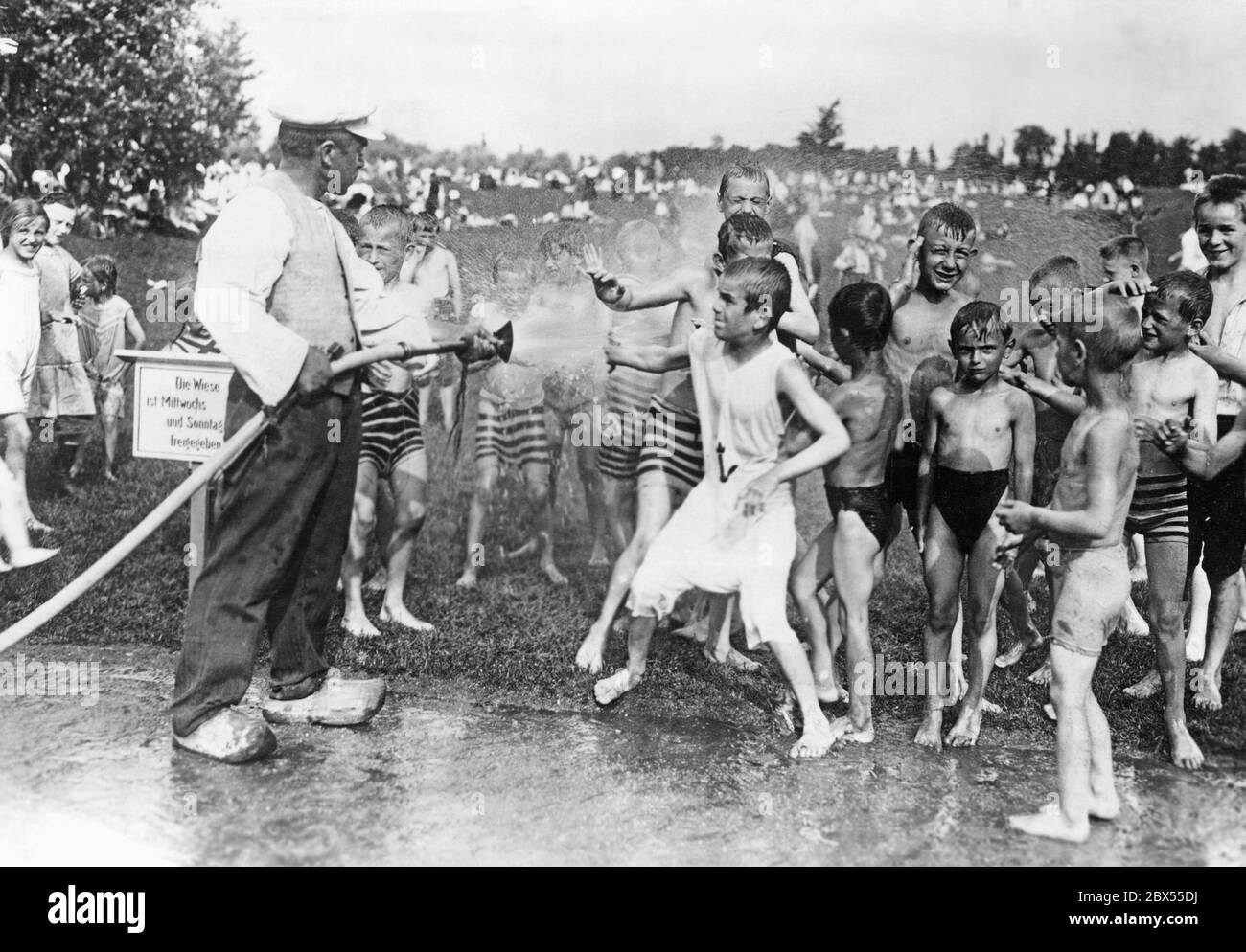 Berlin children are showered with a water hose in the splash zone in Schillerpark. Stock Photo