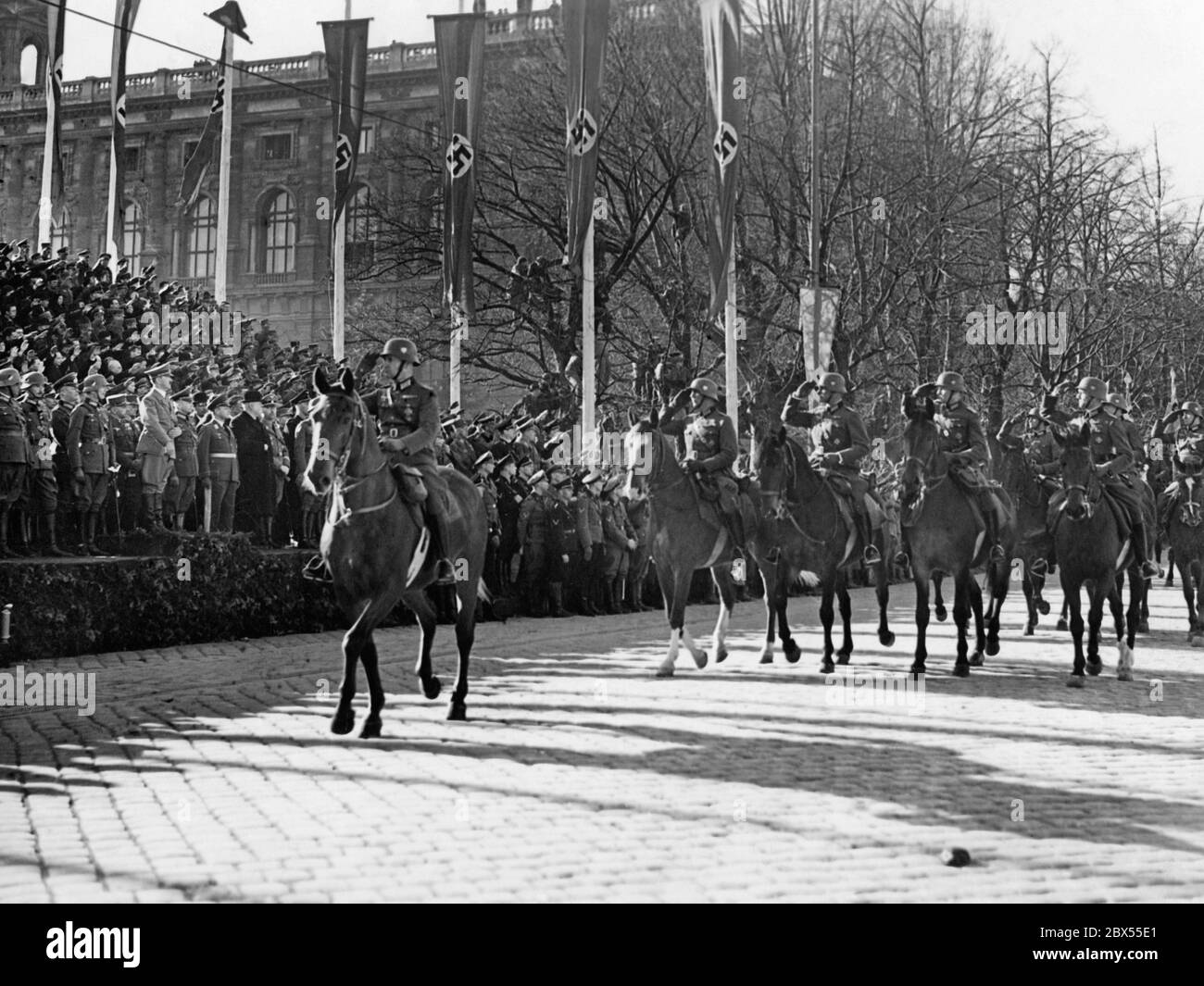 Officers of the officer corps salute on horseback the National Socialist leader Adolf Hitler on the Heldenplatz in Vienna. There he announces the annexation of Austria to the German Reich. Next to Hitler (left) are Generals Fedor von Bock and Alfred Krauss (in civilian clothes) and Reichsfuehrer SS Heinrich Himmler. Stock Photo