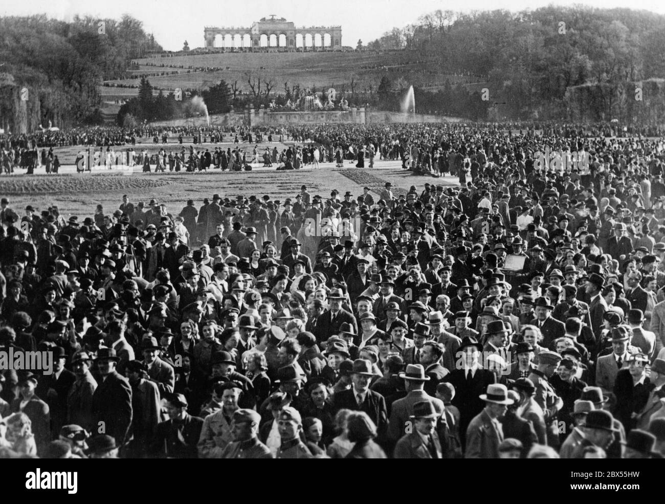 Crowds in the castle park with a view of the Gloriette. The folk festival in the garden of Vienna's Schoenbrunn Palace was organized by the German Police. Austria was annexed to the German Reich in March 1938. Stock Photo