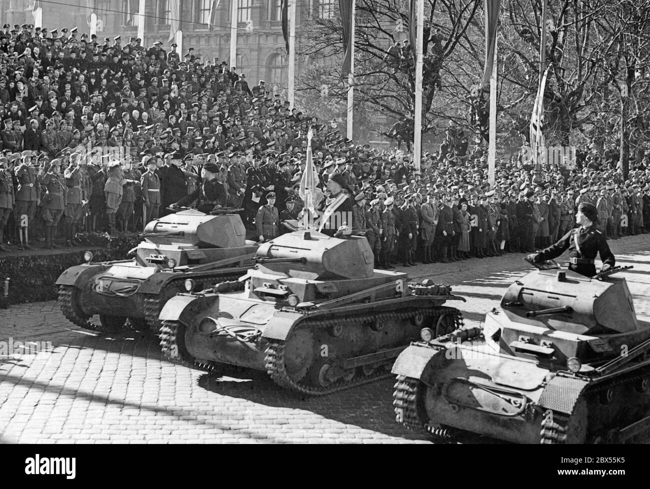 German Panzer II tanks drive past the German dictator Adolf Hitler with a military parade. The parade takes place in the course of Austria's annexation to the German Reich. To the right of Adolf Hitler are the generals Fedor von Bock and Alfred Krauss (in civilian clothes). Stock Photo