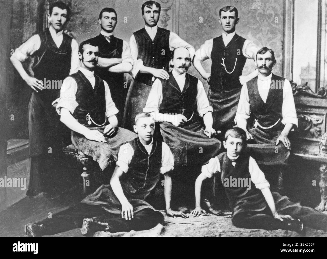 Group photo from the workshop of master tinsmith Anton Porsche in Maffersdorf rechts der Neisse. Right and left of the owner (centre) are the two senior journeymen, behind him are the journeymen and in front are the two apprentices, below them (right) the 14-year-old creator of the Volkswagen, who later became world-famous Professor Dr. Ing. h. c. Ferdinand Porsche. Stock Photo