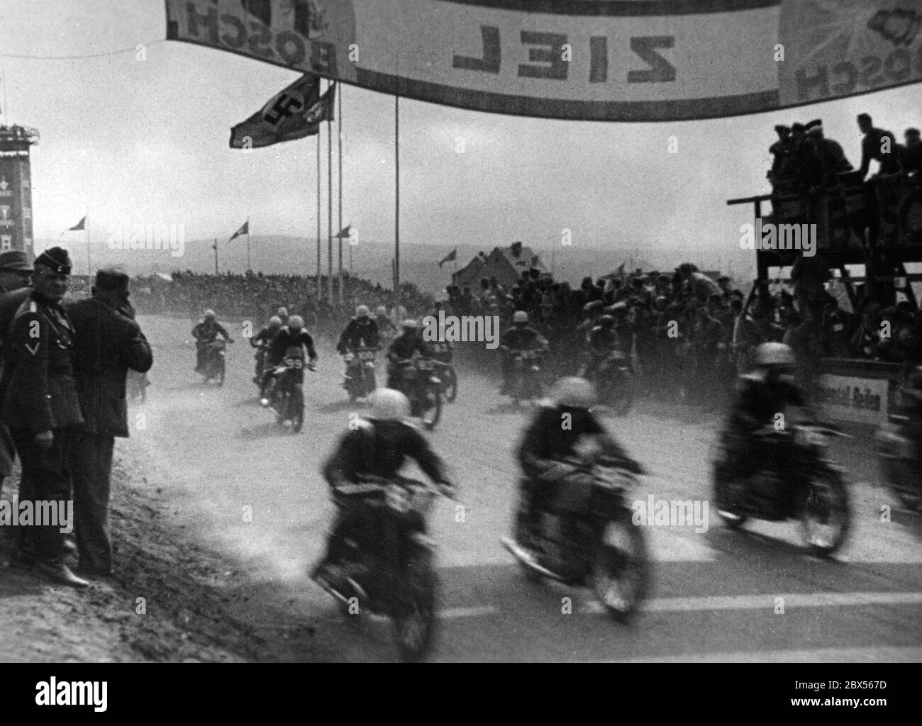 Motorbike racers cross the finishing straight presumably at the XIV German Grand Prix on the Sachsenring in 1939. (Deulig-Tonwoche Nr. 398) Stock Photo