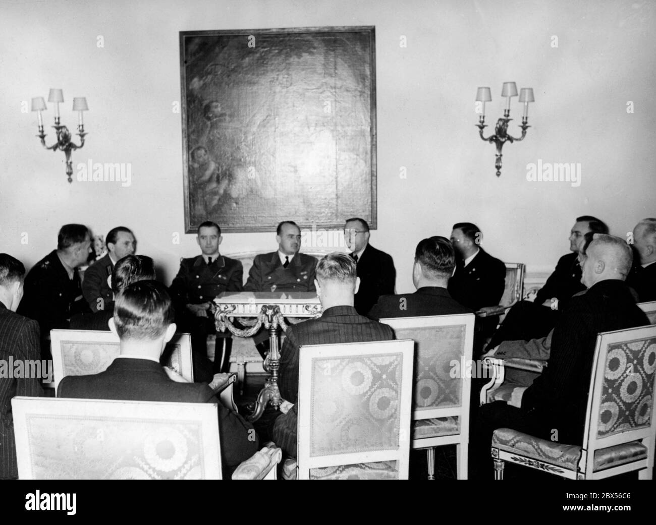 Reich Minister and Governor General of the occupied Poland Hans Frank (centre, below the painting) receives the representatives of the press for a talk on the Victory Day celebrations in Warsaw. Stock Photo