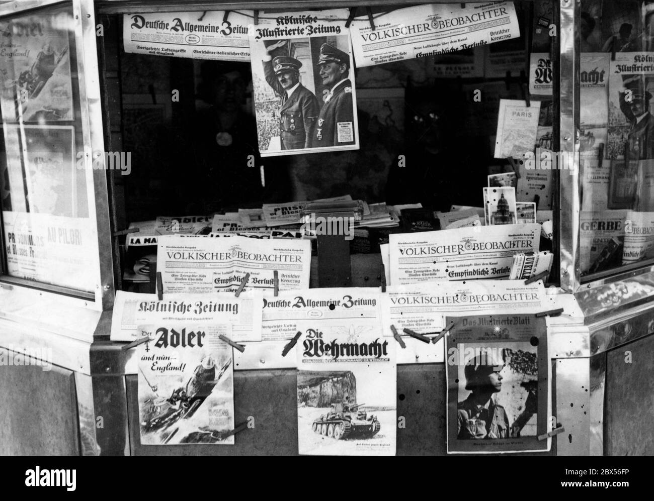 Four weeks after the German invasion of Paris, the newsstands are full of German newspapers and magazines, here on the Boulevard des Italiens, near the opera. Among the newspapers are the Deutsche Allgemeine Zeitung, the Koelnische Illustrierte Zeitung ( title picture with Adolf Hitler and Hermann Goering), Voelkischer Beobachter, Koelnische Zeitung, Deutsche Allgemeine Zeitung, Der Adler ('and now - England'), Die Wehrmacht (ed. by the High Command of the Wehrmacht, title picture: a tank) as well as Das Illustrierte Blatt (title picture: a soldier). Stock Photo