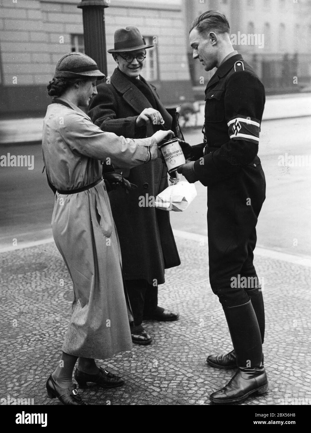 Members of the NSDStB (in uniform) raise money for the Winterhilfswerk des Deutschen Volkes (English: Winter Relief of the German People). Stock Photo