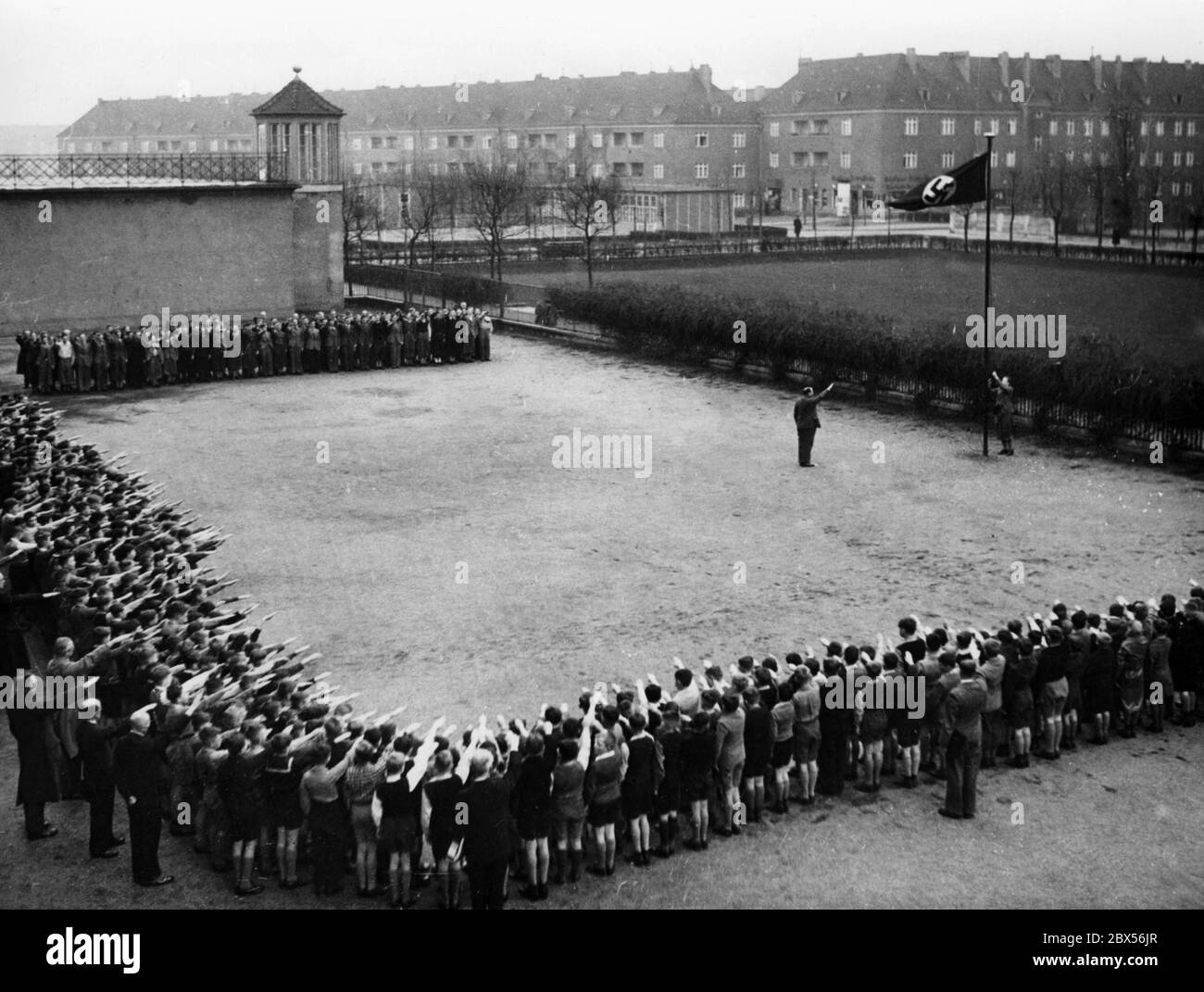 In the schoolyard of the Askanian Gymnasium in Tempelhof a swastika flag is hoisted in front of the lined up students and teachers. Stock Photo