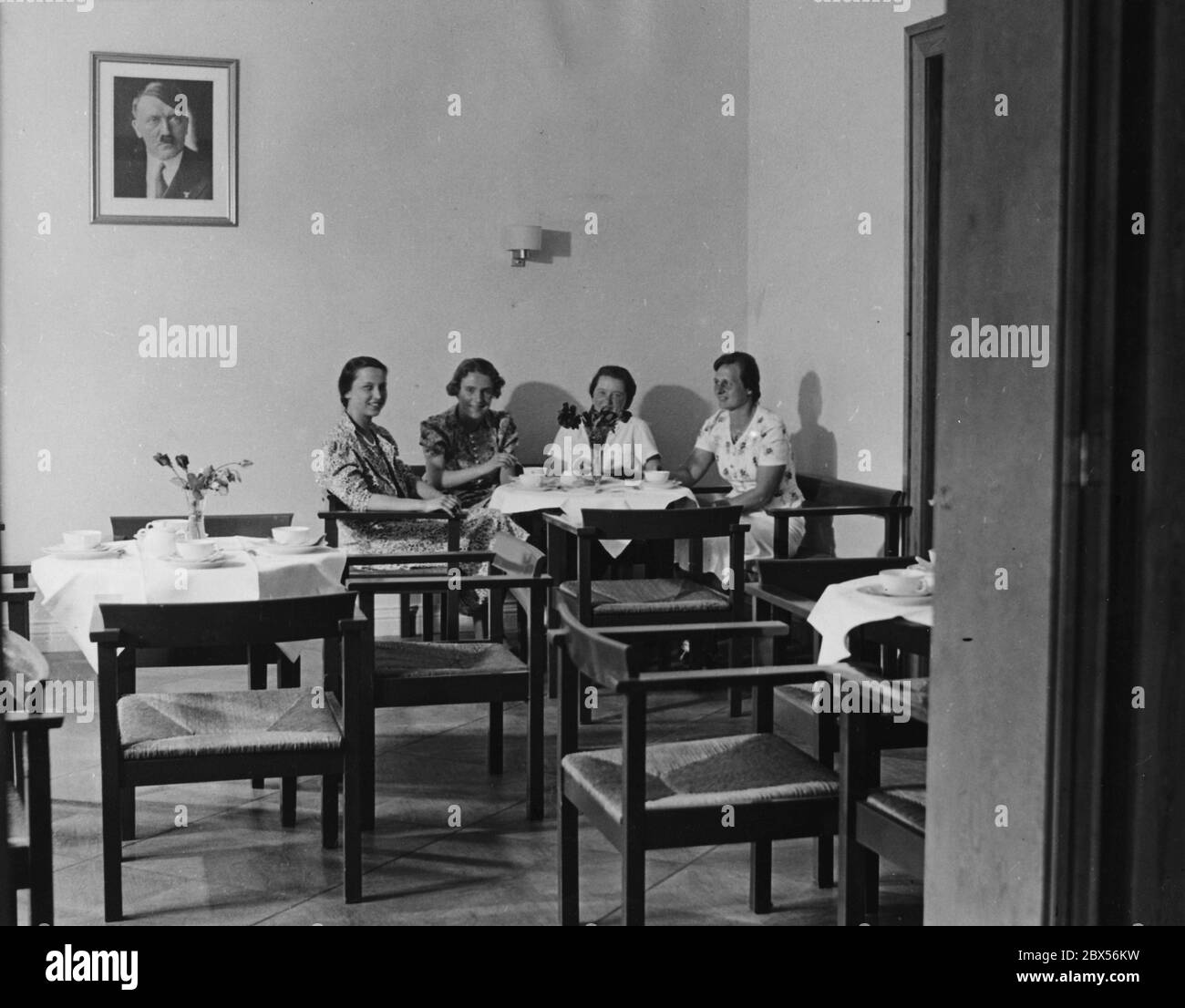 Students of the Labor Association of National Socialist Female Students (Arbeitsgemeinschaft nationalsozialistischer Studentinnen)  in the common room of their new dormitory in Berlin C, Oranienburgerstrasse 19. On the wall is a portrait of Adolf Hitler. Stock Photo