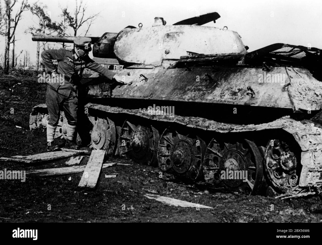 A German officer of the Luftwaffe inspects a destroyed Soviet tank of the type T-45. According to reports of the PK (Propaganda Company) that it was destroyed by hand grenades. During the encirclement battle of Kholm the 'Kampfgruppe Scherer' successfully defended the city for 105 days. (A photo of the Propaganda Company (PK) by war correspondent Richard Muck, who flew into the pocket at the beginning of March). Stock Photo