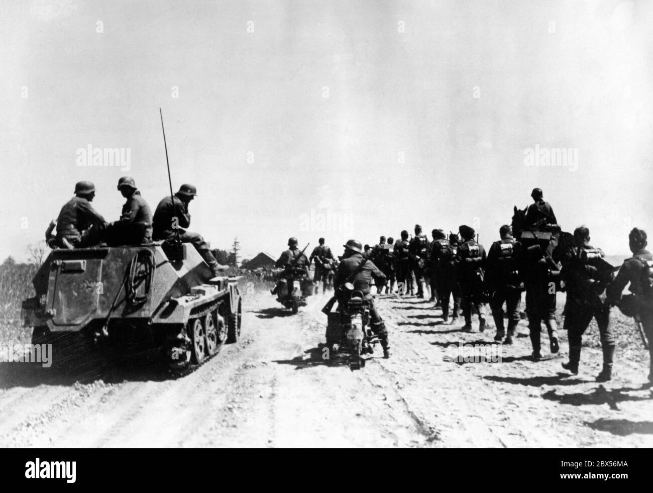 German infantry and an Sd.Kfz. 250 (Schuetzenpanzerwagen Sd.Kfz. 250) infantry fighting vehicle (left) on the advance near Virbalis (German: Wirballen) on the border to Lithuania. Area Army Group North (Heeresgruppe Nord). Stock Photo