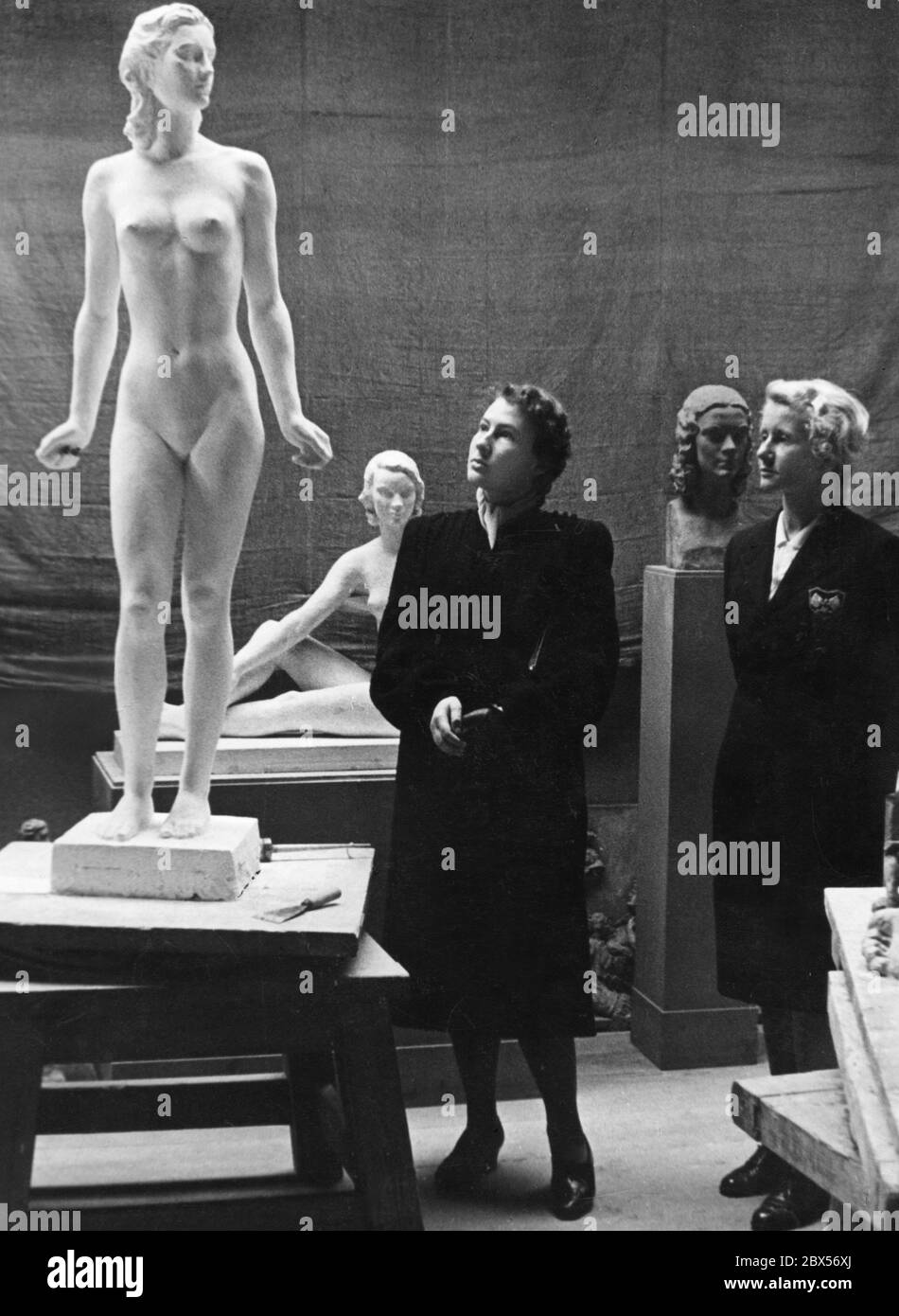 Visitors to an exhibition view the sculpture 'Die Jugend' (The Youth) by Fritz Klimsch. Stock Photo