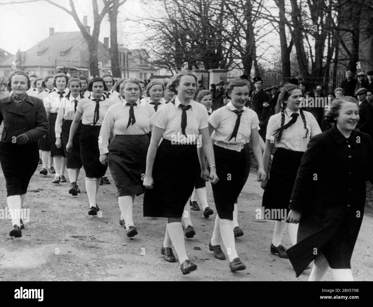 A group of German girls in Kaesmark marches to the gym. In the background there is a boy with a swastika armband. Stock Photo