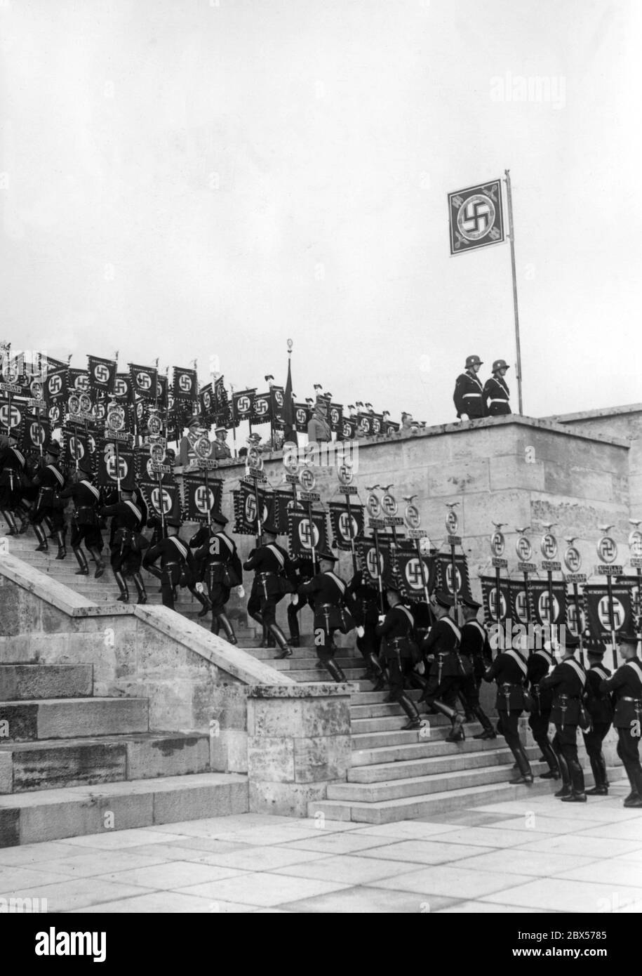 During the Reich Party Congress of Labour, a grand roll call is held in Nuremberg's Luitpold Arena on the Reich Party Rally Grounds, where the standard bearers of the SS march up the rostrum. Stock Photo