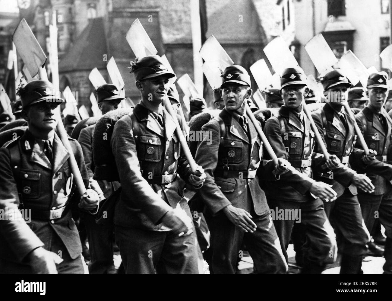 Men of the Reich Labor Service march through the streets of Nuremberg with their spades, after the roll call on the Zeppelin Field to the Reich Party Congress. Stock Photo