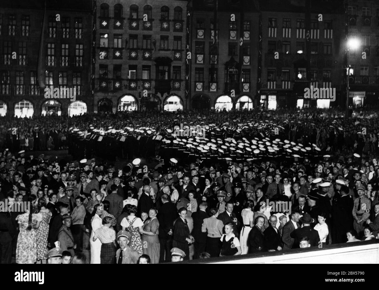 The marching band of the I and II Marineunteroffizierslehrabteilung ('Warrant Officer Training Division') perform in the evening on the so-called Adolf-Hitler-Platz during the Reich Party Congress in Nuremberg. Stock Photo