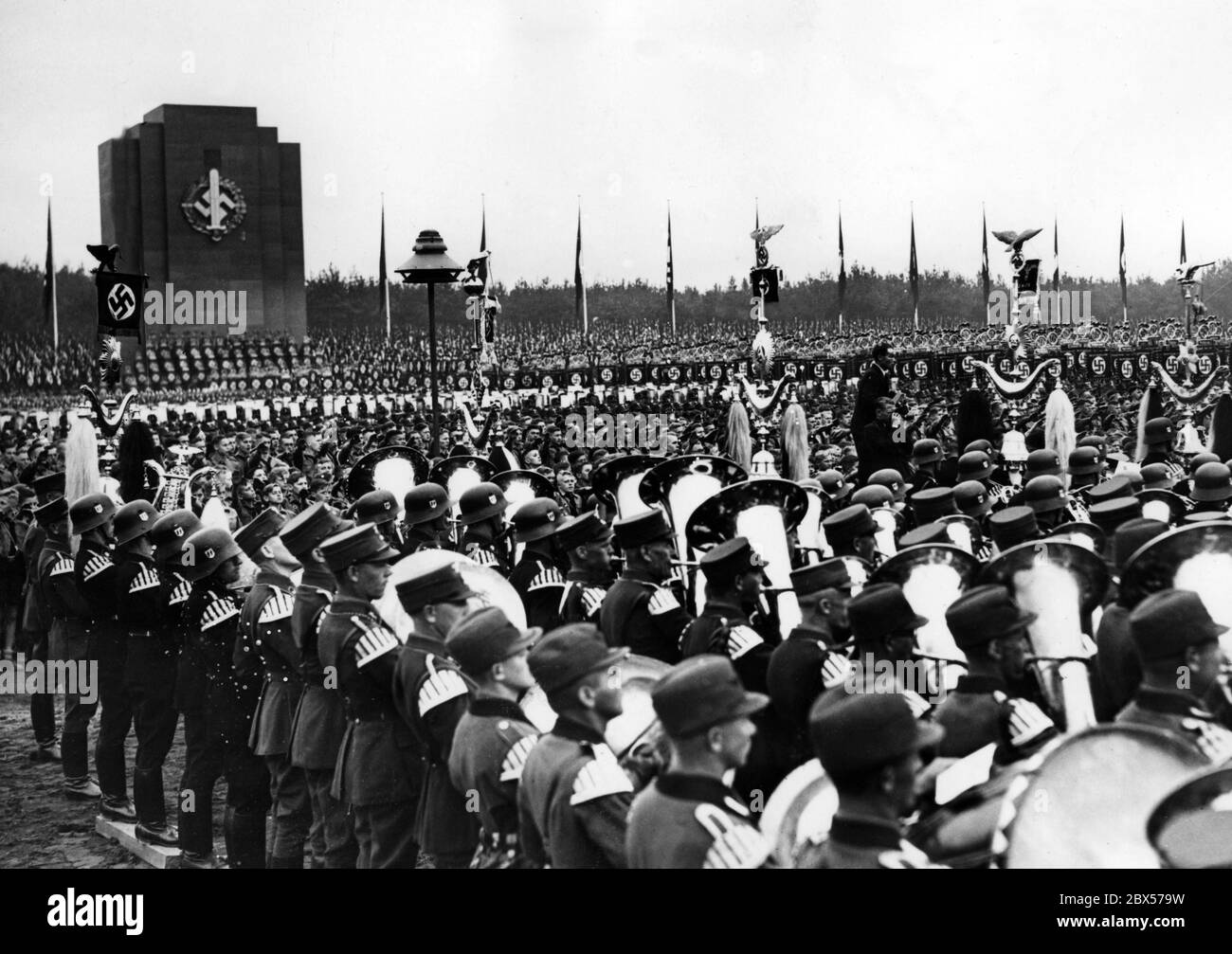 Overview of the celebrations for the opening of the NS-Kampfspiele (NS fighting games) and the laying of the foundation stone for the German Stadium on the Reich Party Rally Grounds. The SA Sports Badge is displayed on the tower. In the foreground there is a music band. Stock Photo