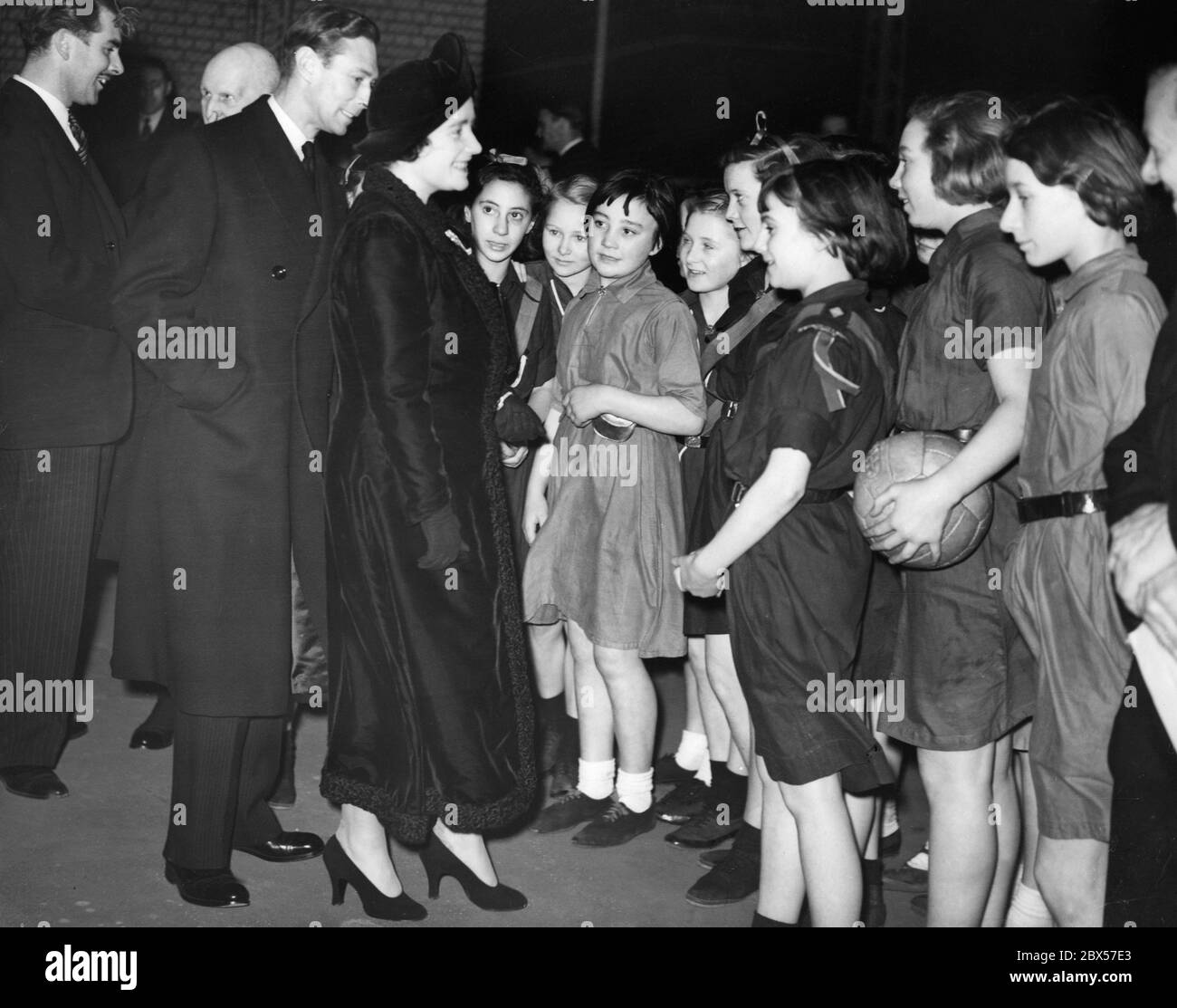 Queen Elizabeth and King George VI in conversation with girls from the Bermondsey and Stepney Girl Guides who played netball on the roof of Toynbee Hall in the East End Social Centre in Aldgate. Stock Photo