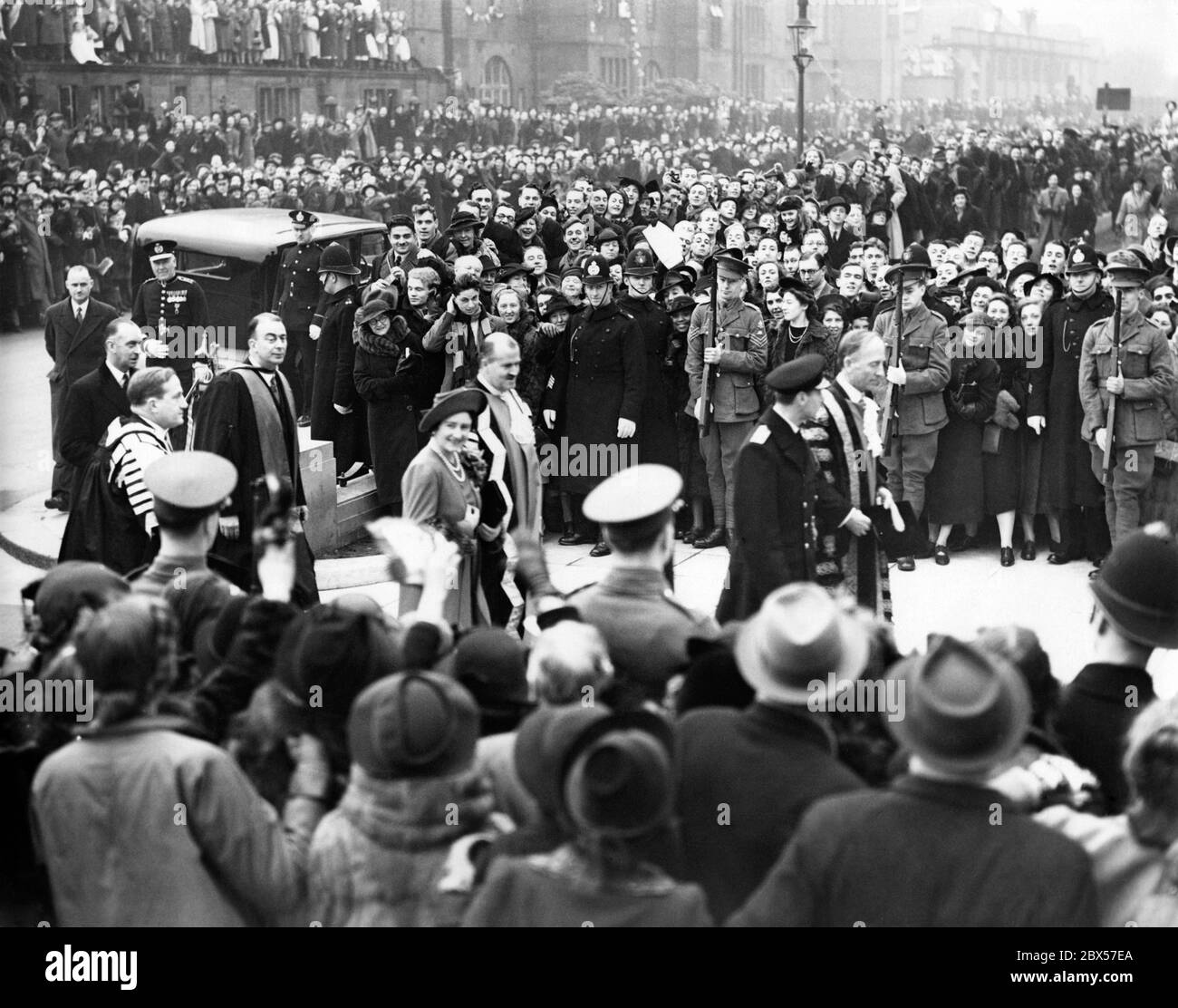 Queen Elizabeth and King George VI on their arrival at City Hall, Newcastle, for the inauguration of the new battleship 'King George V' at Wallsend. Lord Londonderry is walking beside the king. Stock Photo